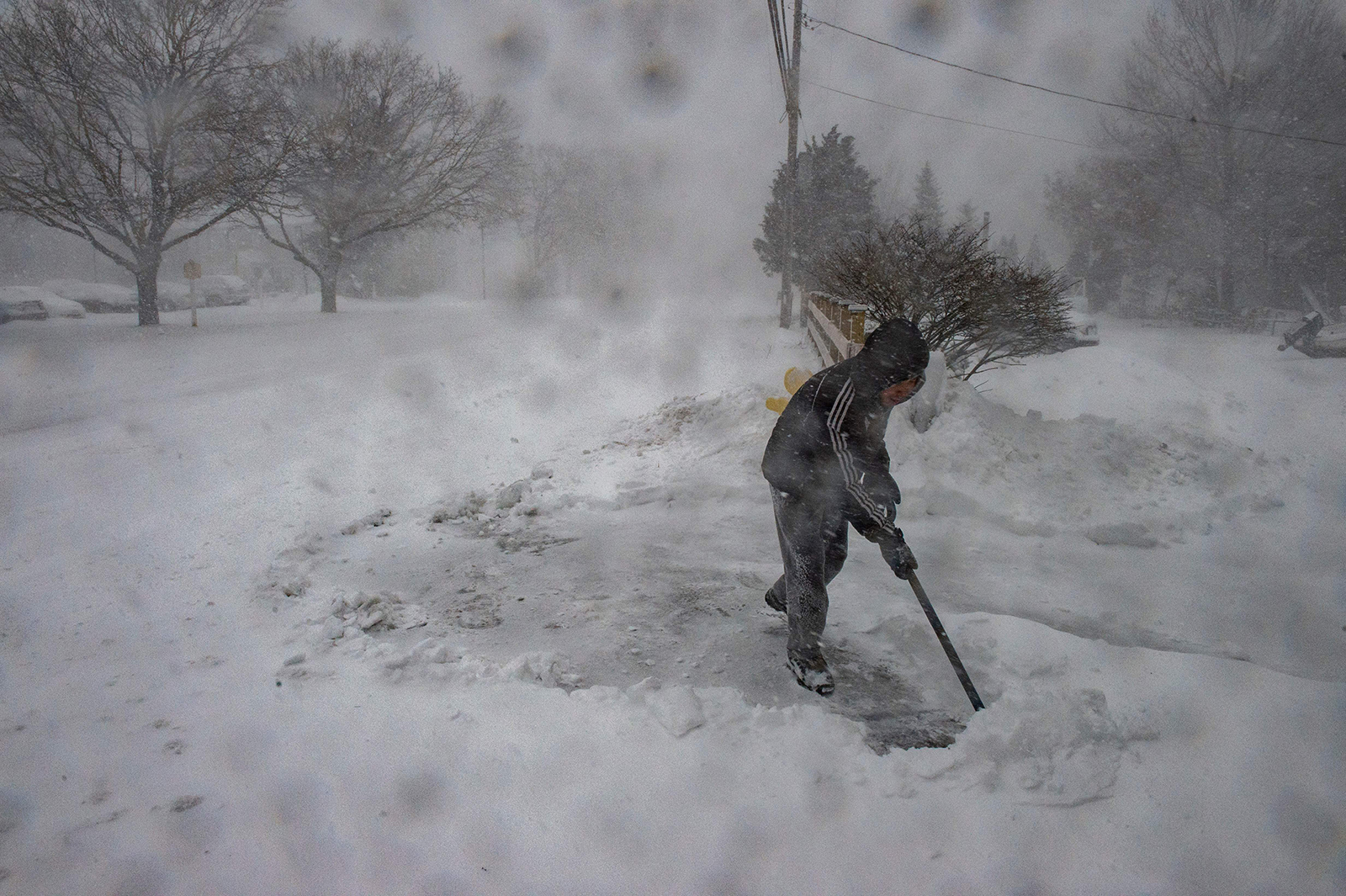 A man shovels snow in near-white conditions during a ski event in Marshfield, Massachusetts, on January 29.