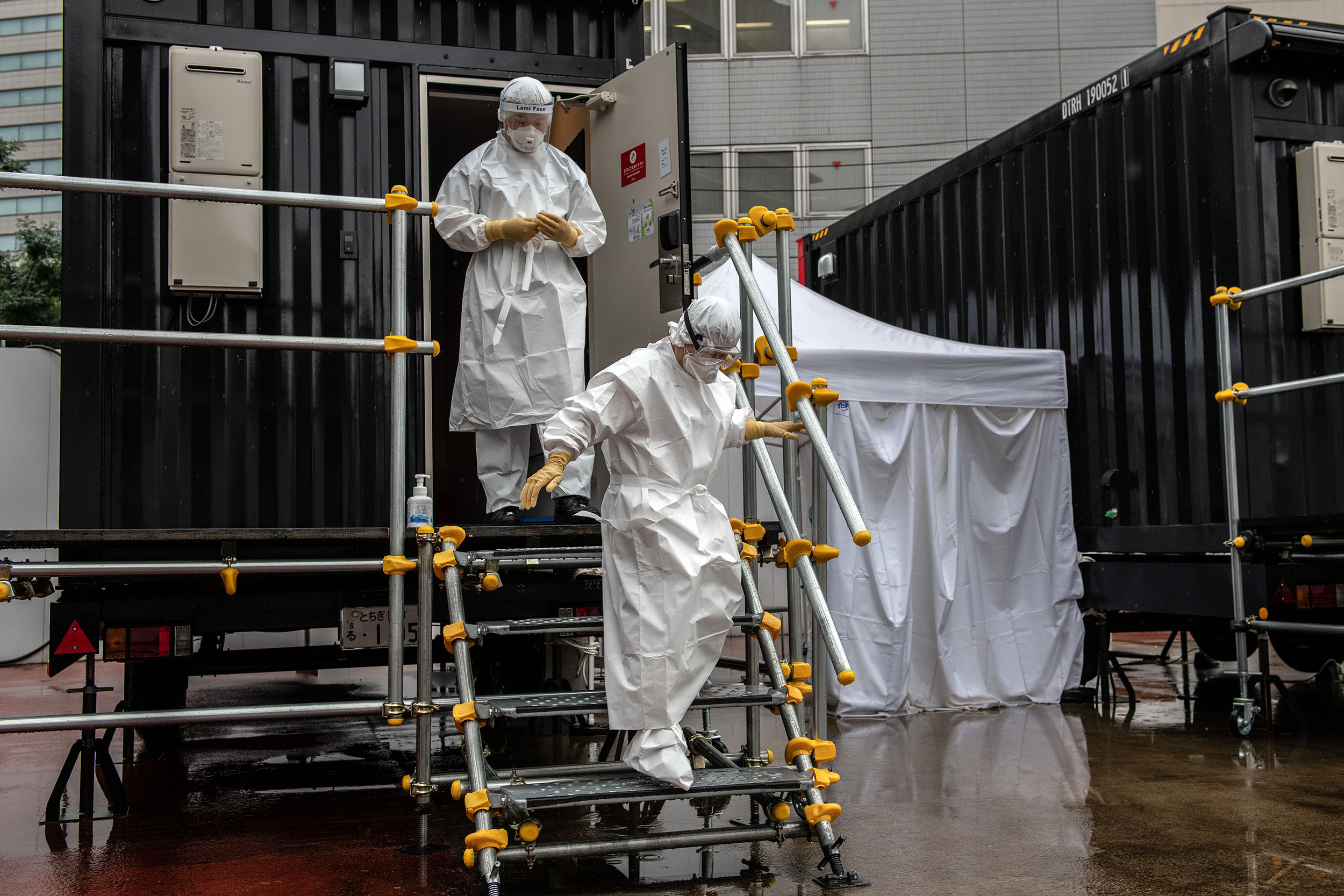 A nurse and doctor exit a changing room during a coronavirus polymerase chain reaction (PCR) demonstration test on July 14, in Tokyo, Japan. 
