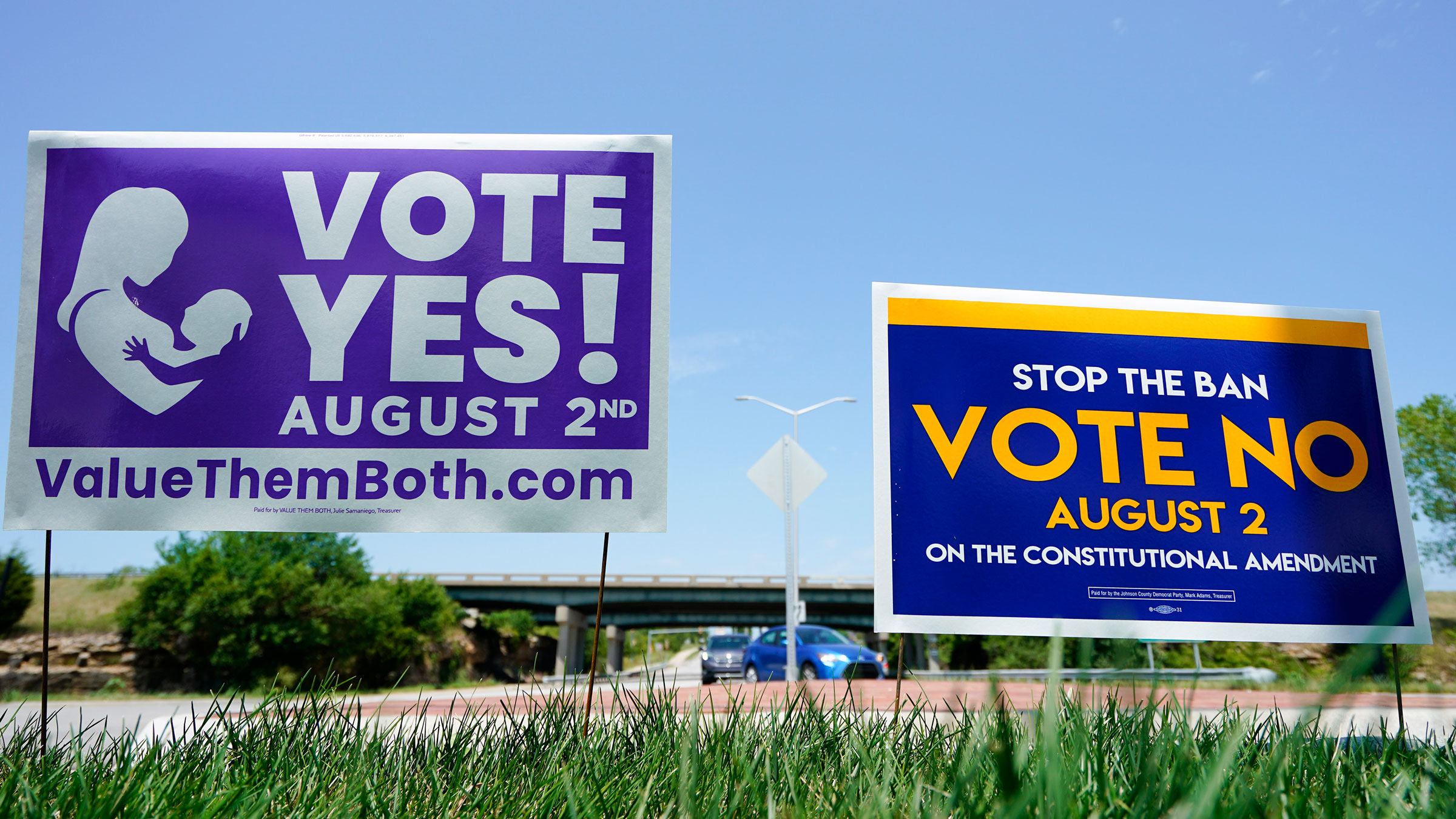 Signs are displayed by a road in Lenexa, Kansas, on Monday.
