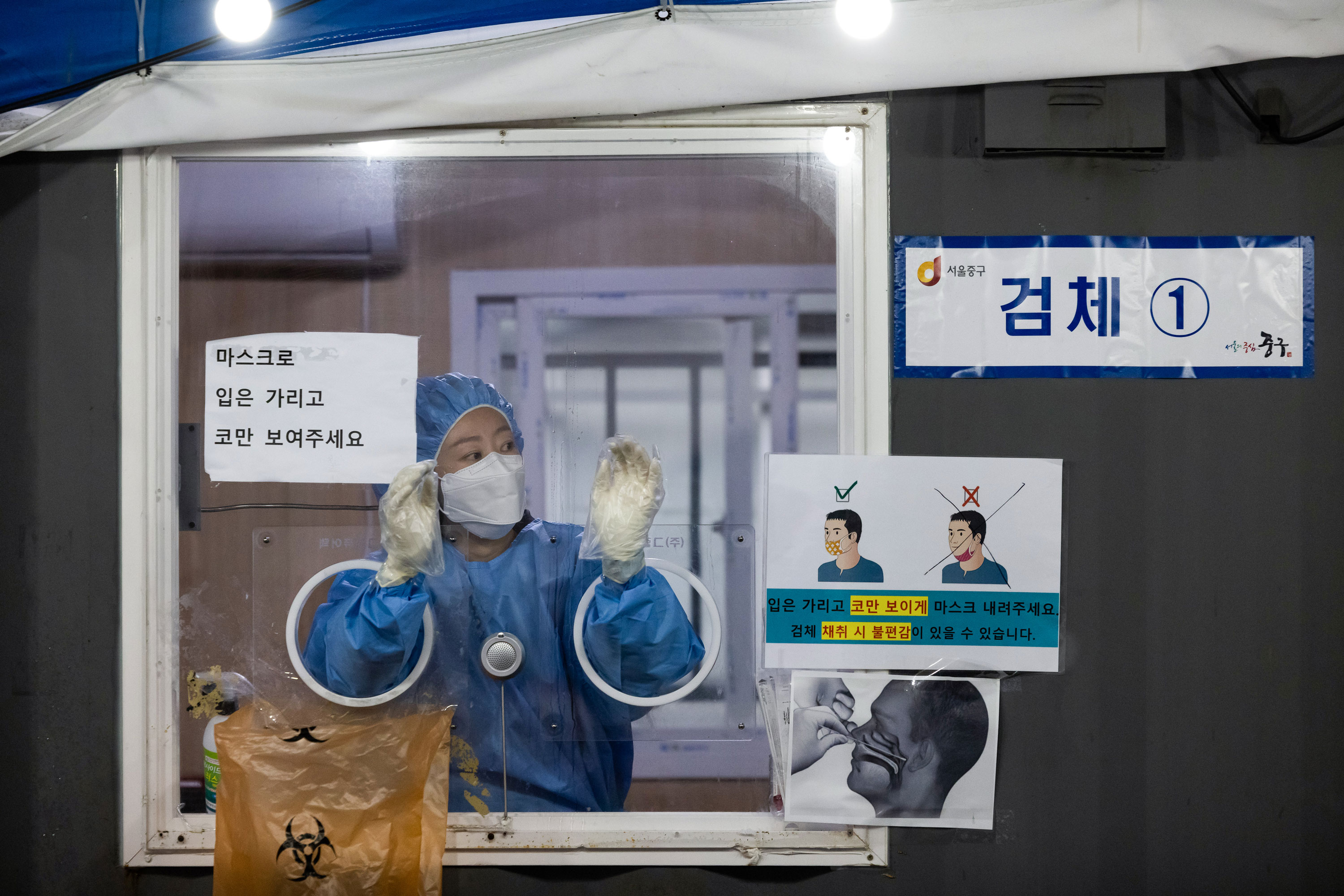 A healthcare worker prepares to administer a Covid-19 test at a temporary testing site outside Seoul Station in Seoul, South Korea, on Tuesday, Nov. 30, 2021.
