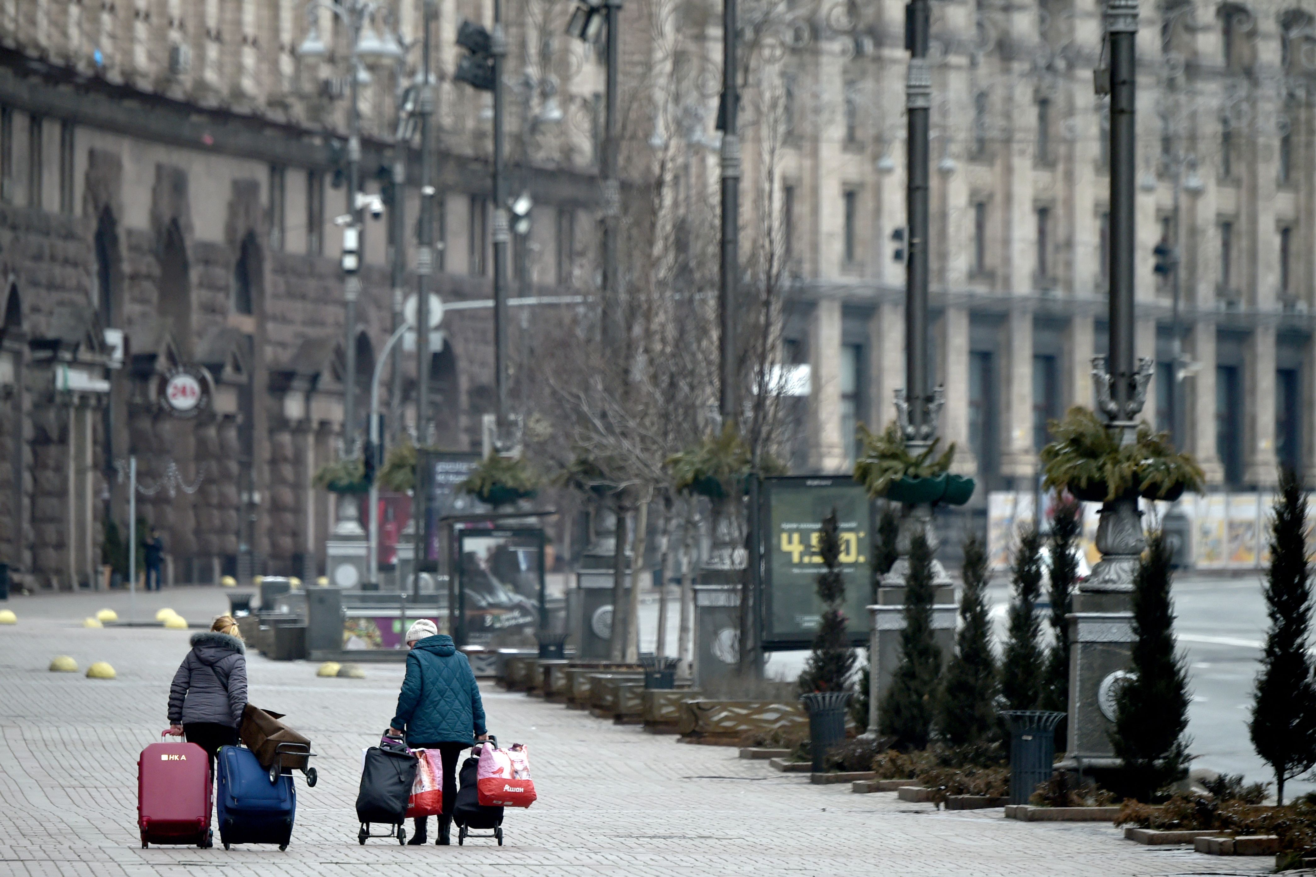 Women carry their belongings as they walk on a deserted street in Kyiv on March 1. 