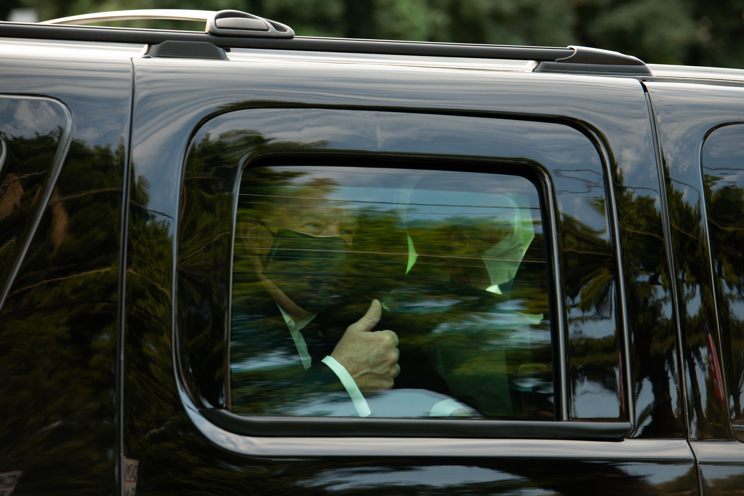 President Donald Trump gives a thumbs up while greeting his supporters outside of Walter Reed National Military Medical Center in Bethesda, Maryland, on Sunday, October 4, 2020. 