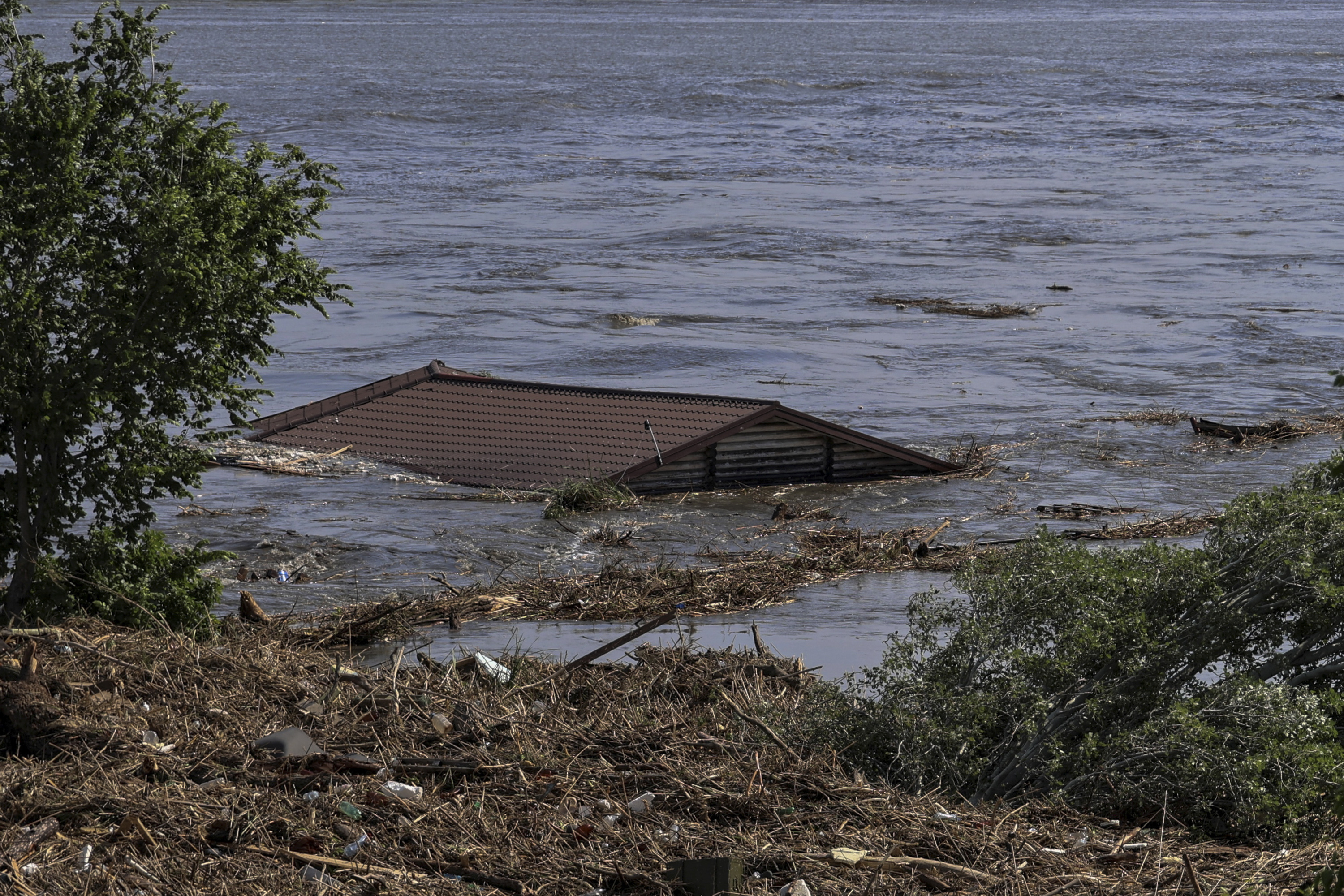 The roof of a house is seen in the flooded Dnipro river in Kherson, Ukraine on June 6. 