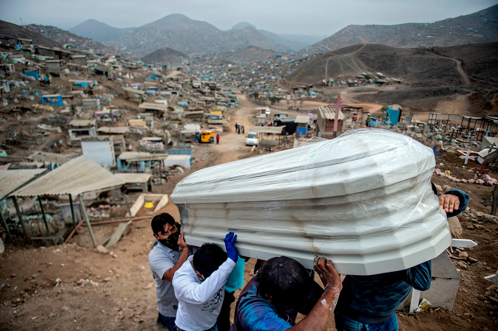 Relatives carry the coffin of a suspected COVID-19 victim at the Nueva Esperanza cemetery in the southern outskirts of Lima, Peru, on May 30.