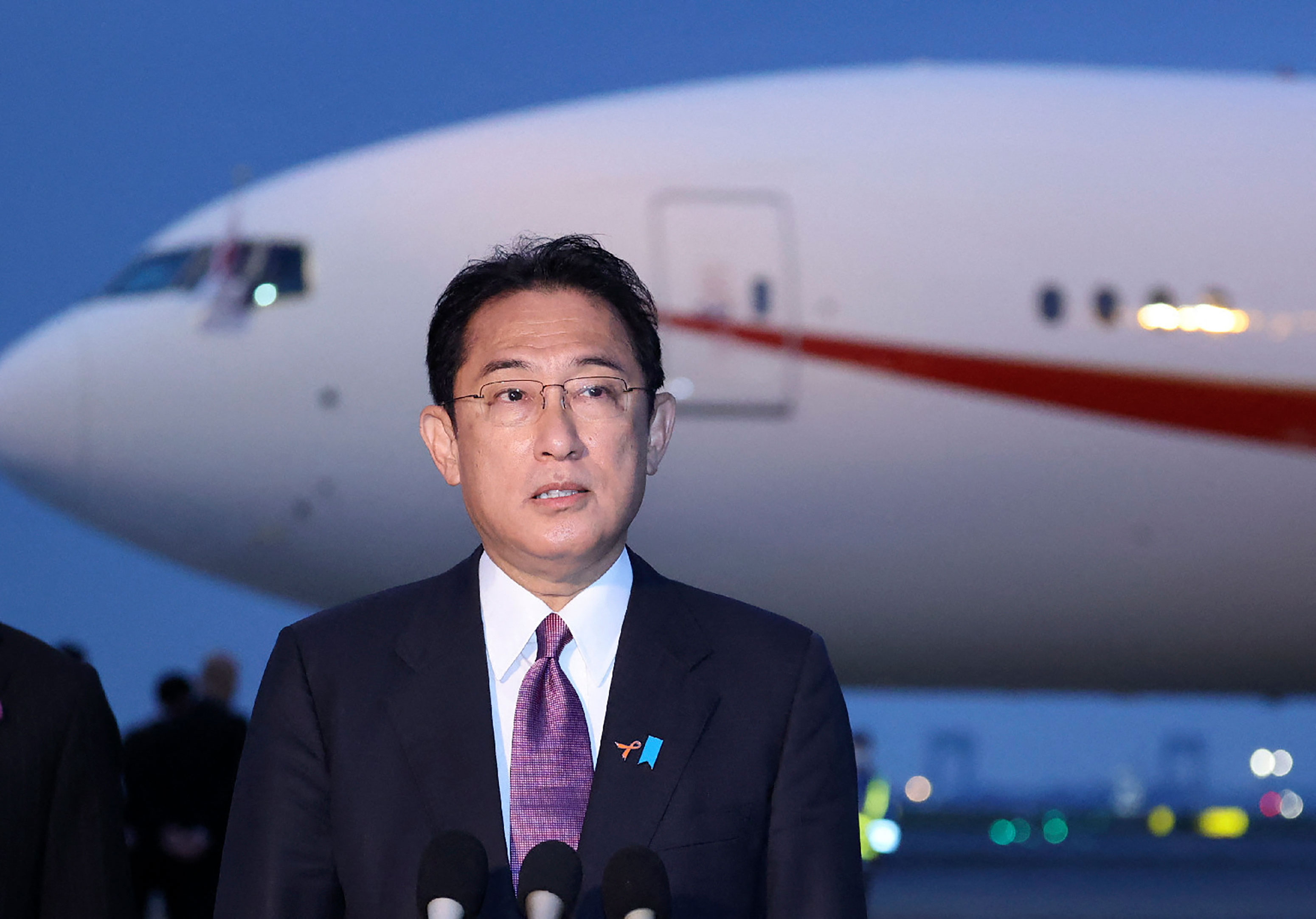 Japan's Prime Minister Fumio Kishida speaks to reporters at Tokyo's Haneda Airport on November 2, before traveling to the UK to attend COP26.