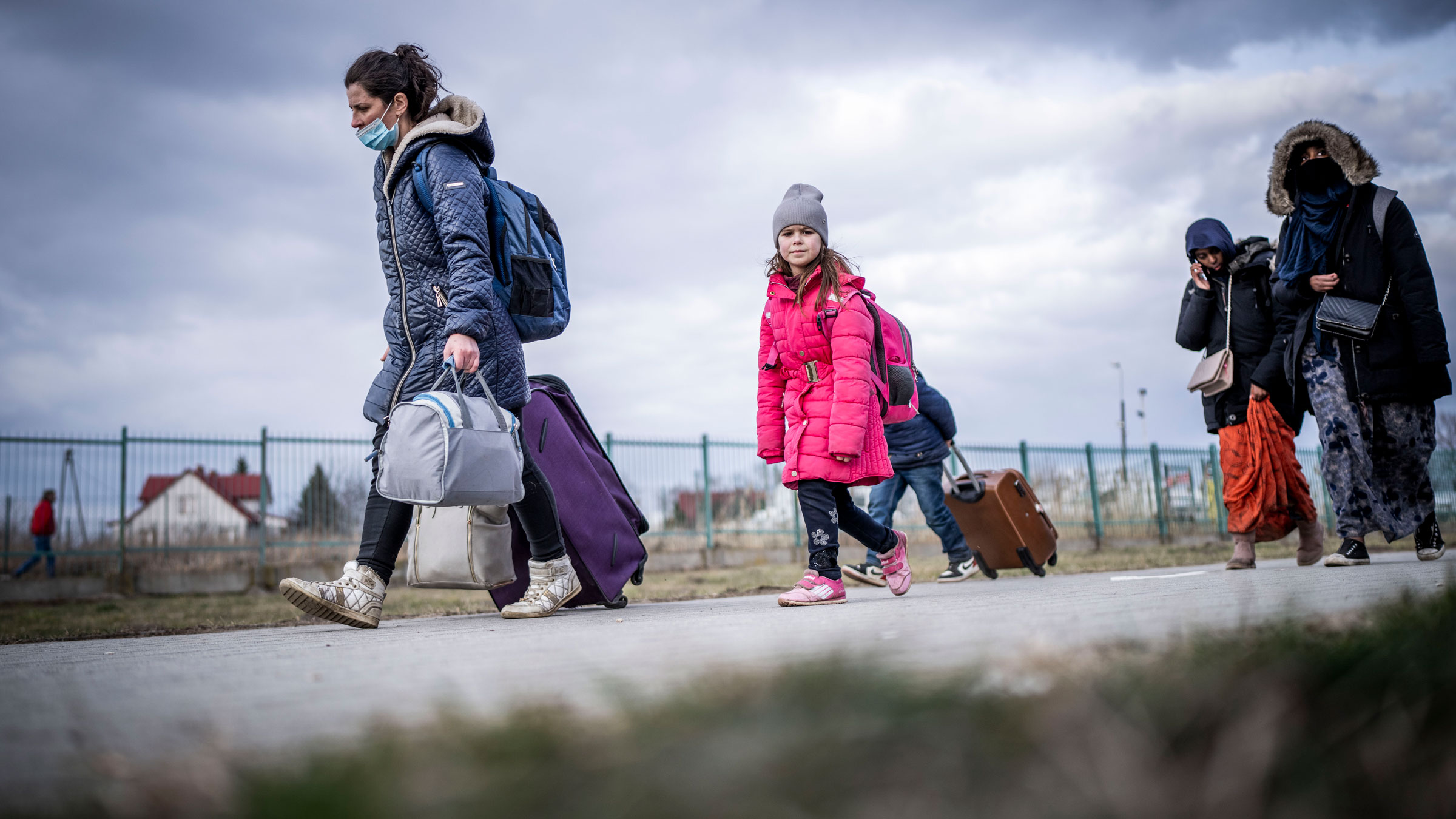 Refugees from Ukraine walk into Przemysl, Poland, after crossing the border on Saturday.