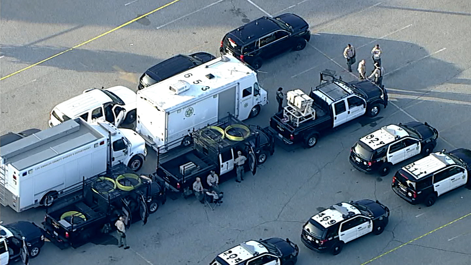 This aerial view shows police vehicles and a law enforcement mobile command post gathering at the FBI's Los Angeles field office parking lot in Loas Angeles, California.
