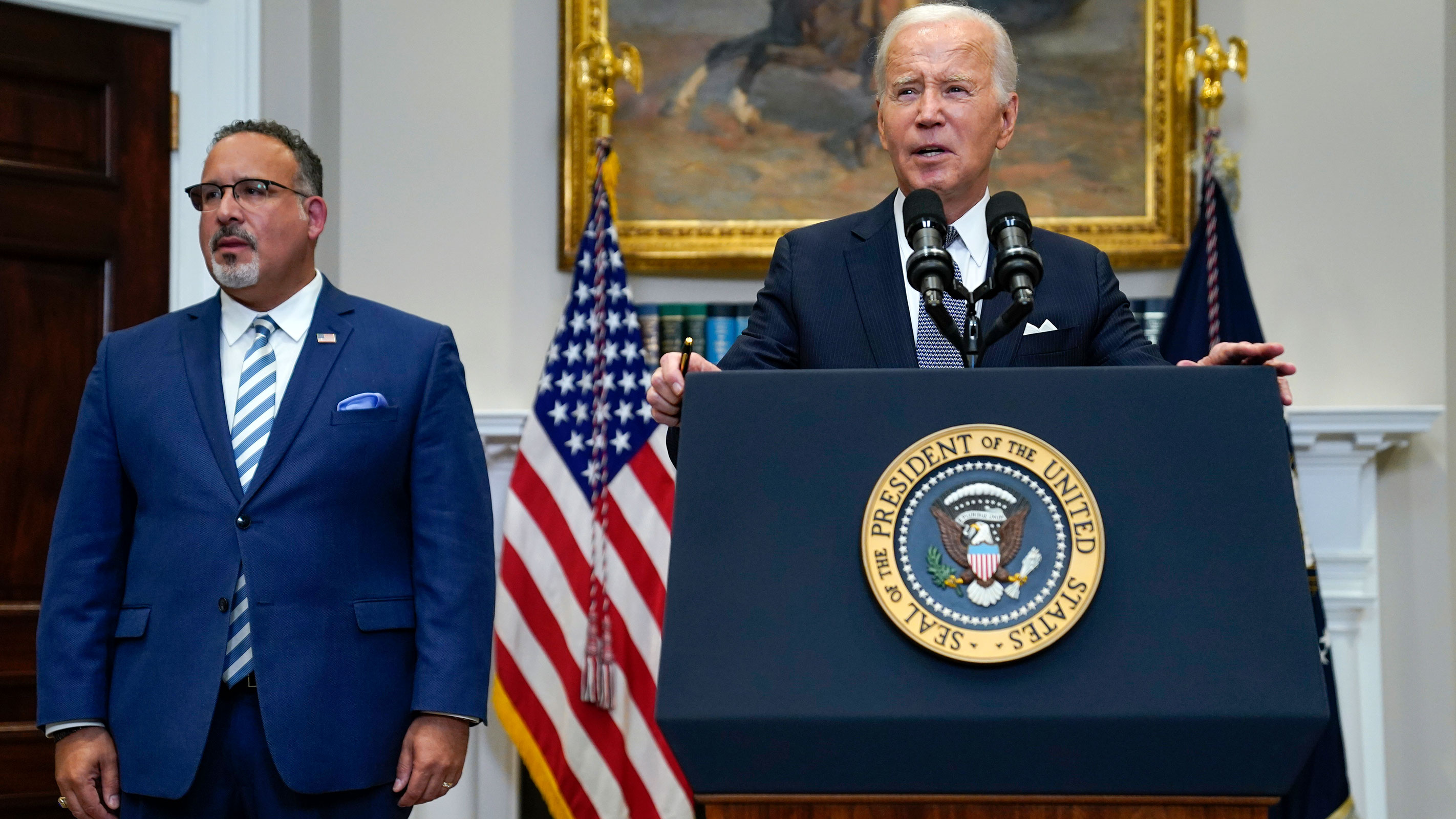 President Joe Biden speaks in the Roosevelt Room of the White House, Friday, June 30, 2023 after the Supreme Court struck down his student loan forgiveness plan. Education Secretary Miguel Cardona listens at left.