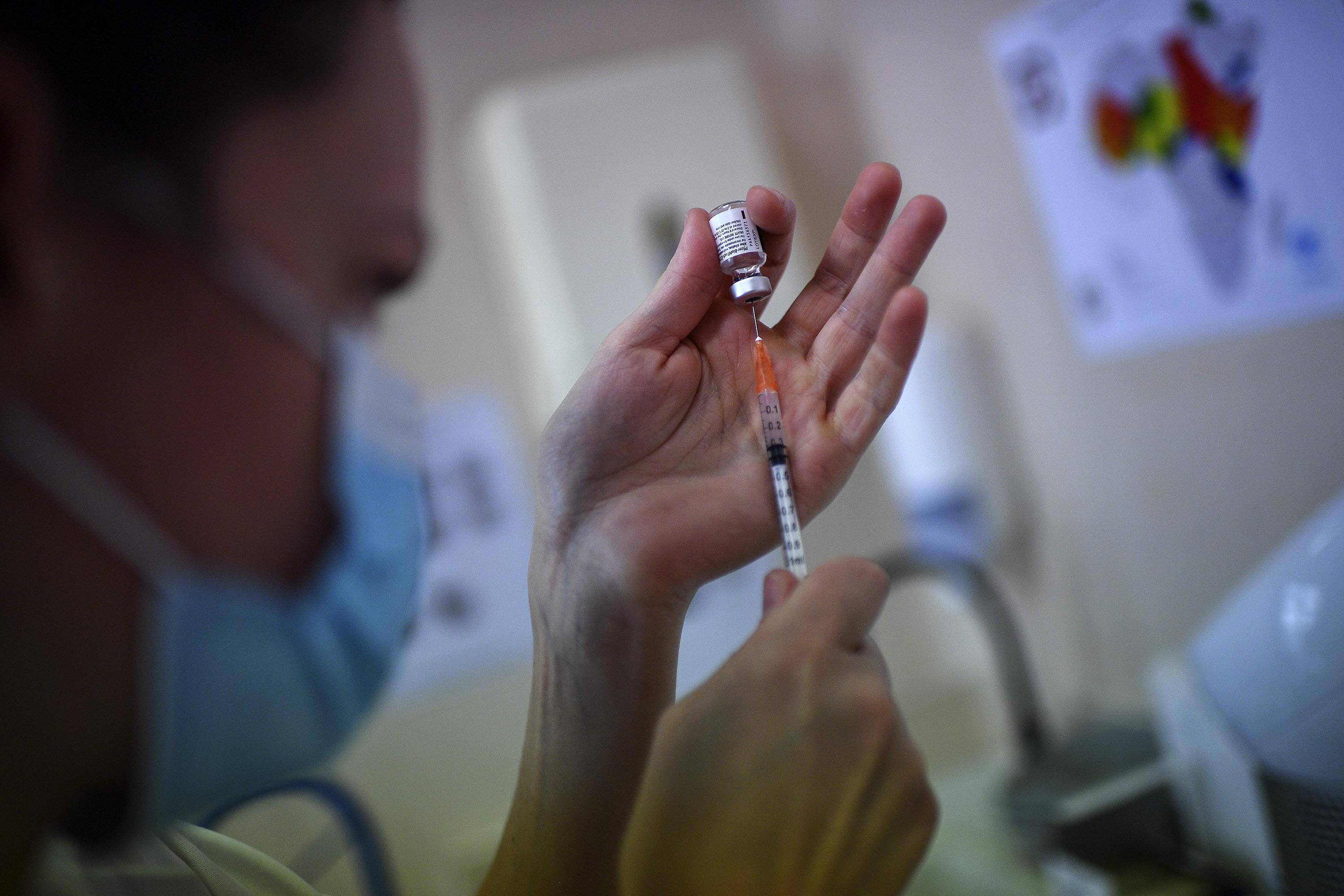 A nurse fills a syringe with a vial of the Pfizer/BioNTech vaccine at the Pasteur Institute, in Paris, on January 21.