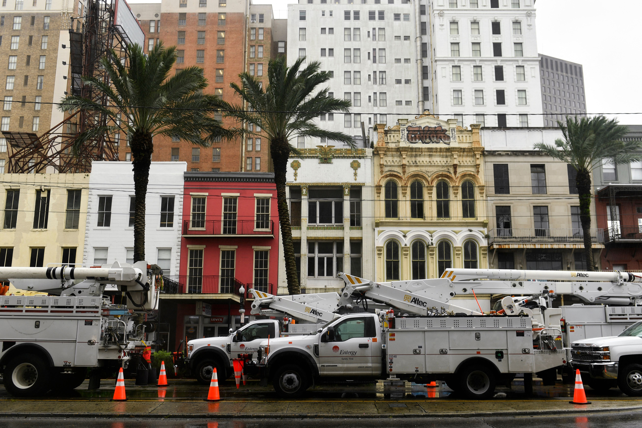 Entergy Corp. electric utility company bucket trucks are staged on Canal Street in New Orleans on Sunday, August 29, during Hurricane Ida.