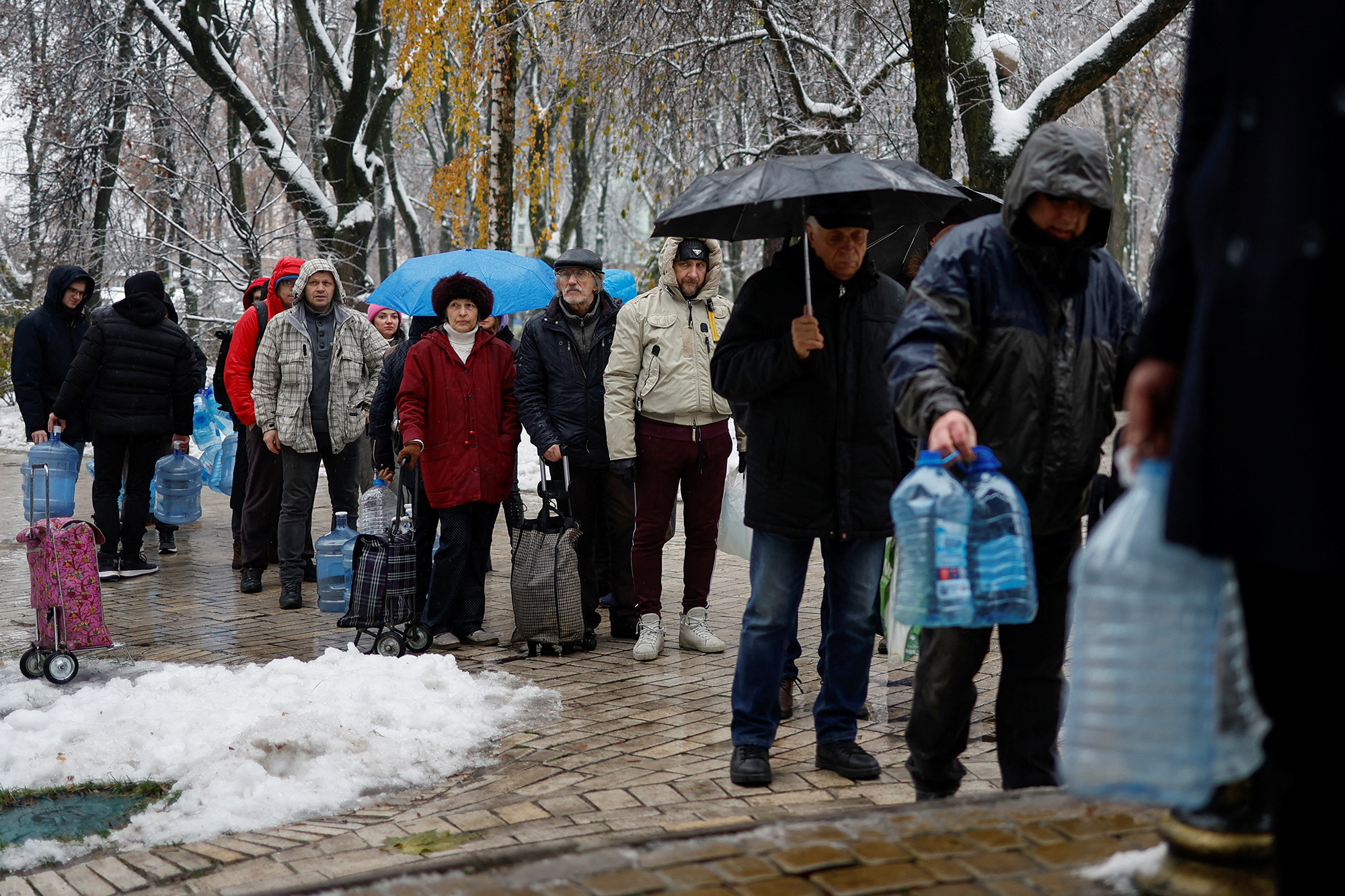 Local residents stand in line to fill up bottles with fresh drinking water in Kyiv, Ukraine, on November 24.