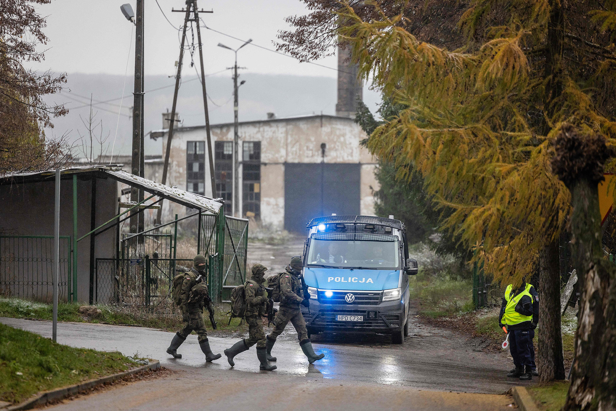 Polish soldiers pass by the police check point, next to site where a missile strike killed two men, in Przewodow, Poland, on November 17.
