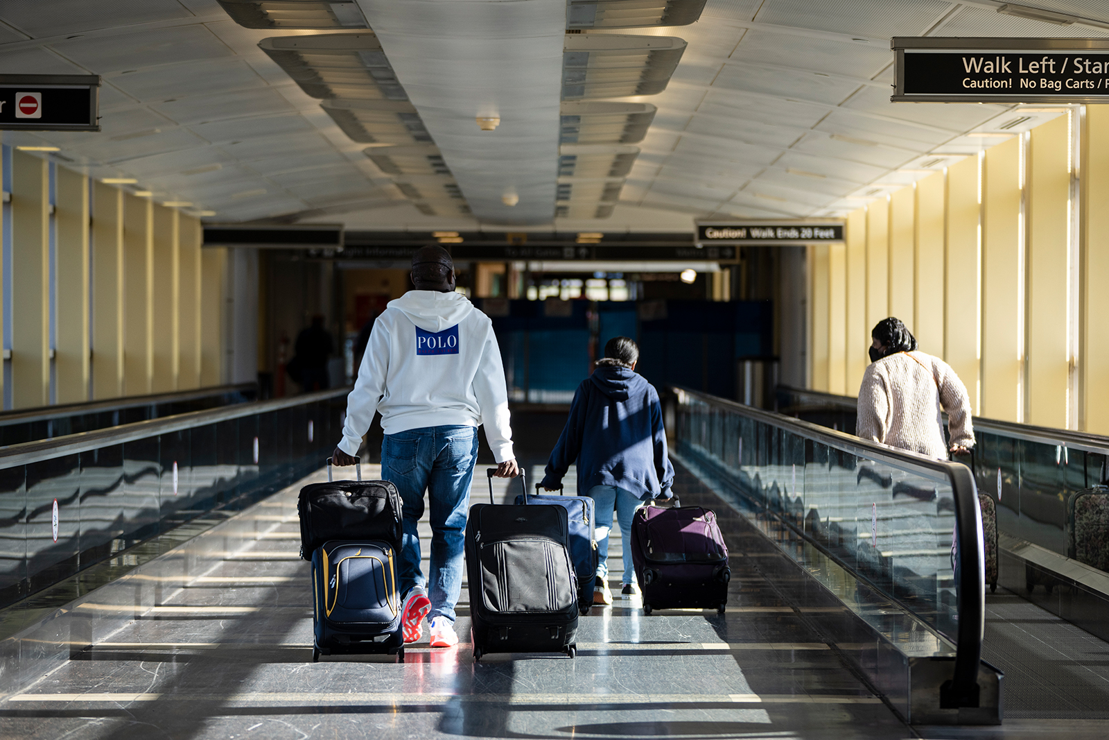 Travelers carry luggage upon arrival at Ronald Reagan Washington National Airport on November 23, in Arlington, Virginia. 