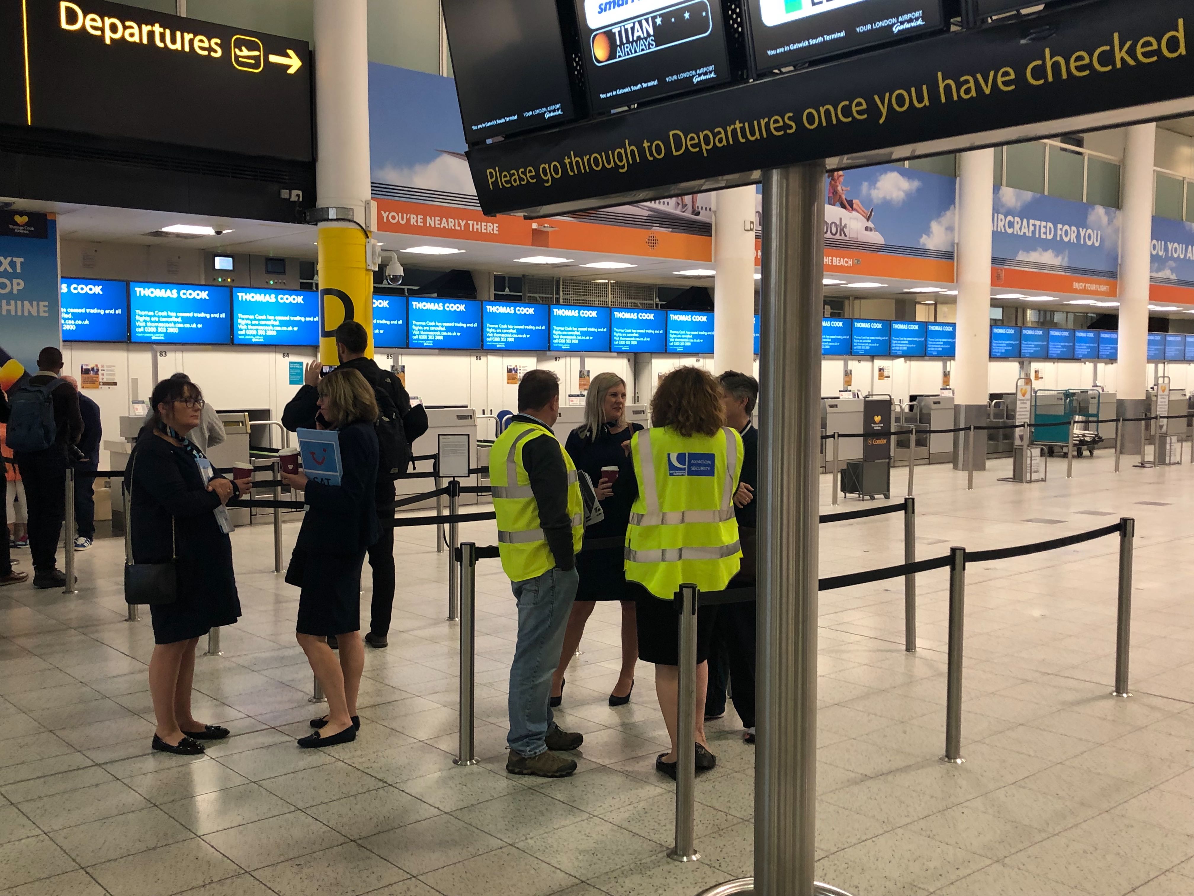 CAA officials help passengers at Gatwick Airport.
