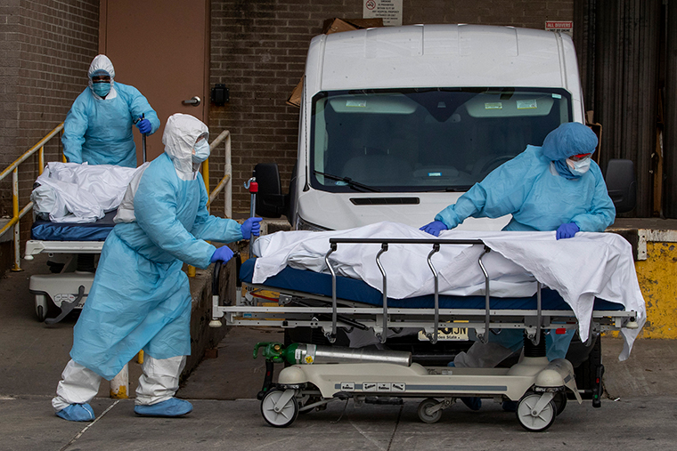 Medical personnel wearing personal protective equipment remove bodies from the Wyckoff Heights Medical Center Thursday, April 2, 2020 in Brooklyn.