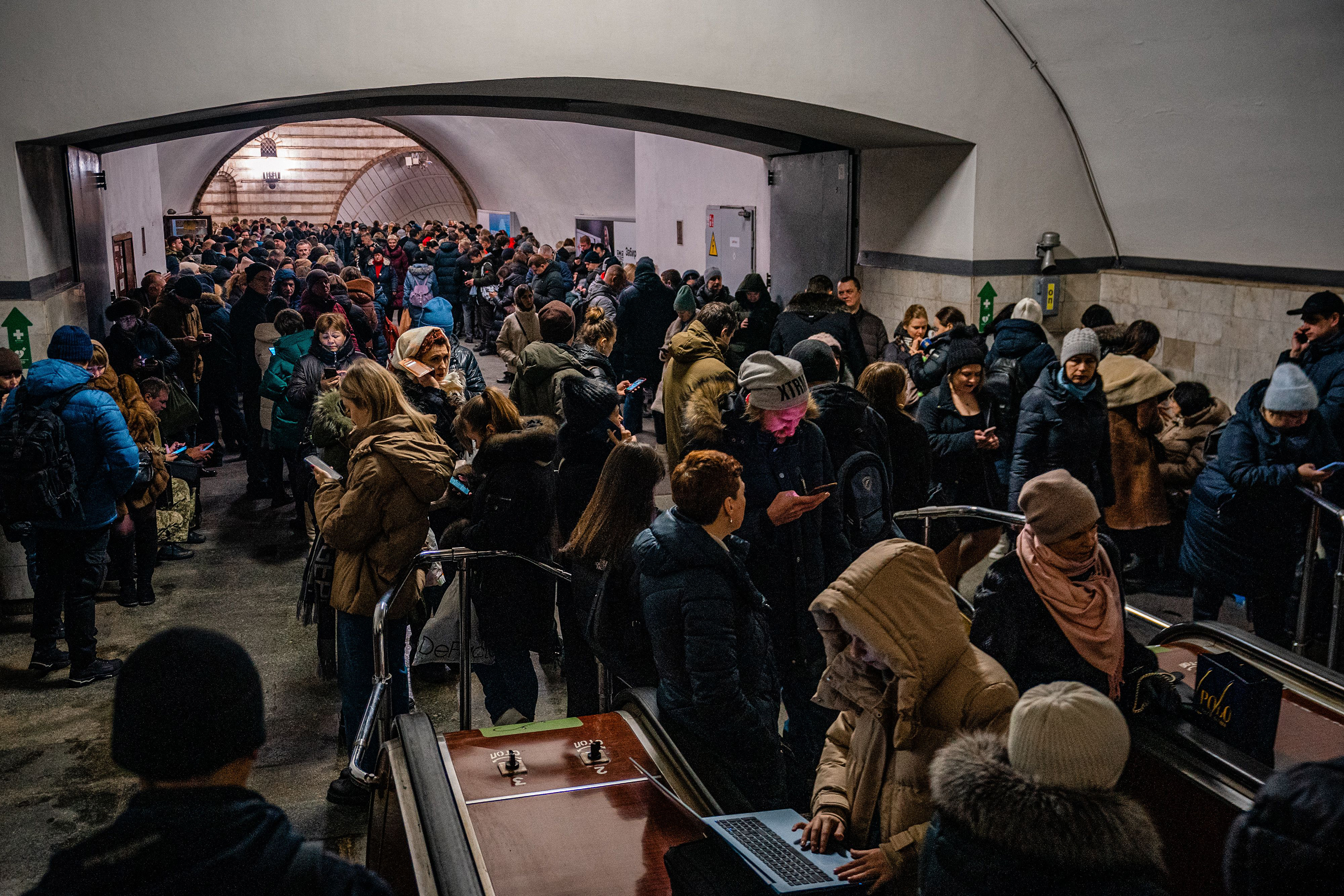 Civilians take shelter inside a metro station in Kyiv as a fresh barrage of Russian strikes hit cities across Ukraine early on Friday cutting water and electricity in major cities and piling pressure on Ukraine's grid.