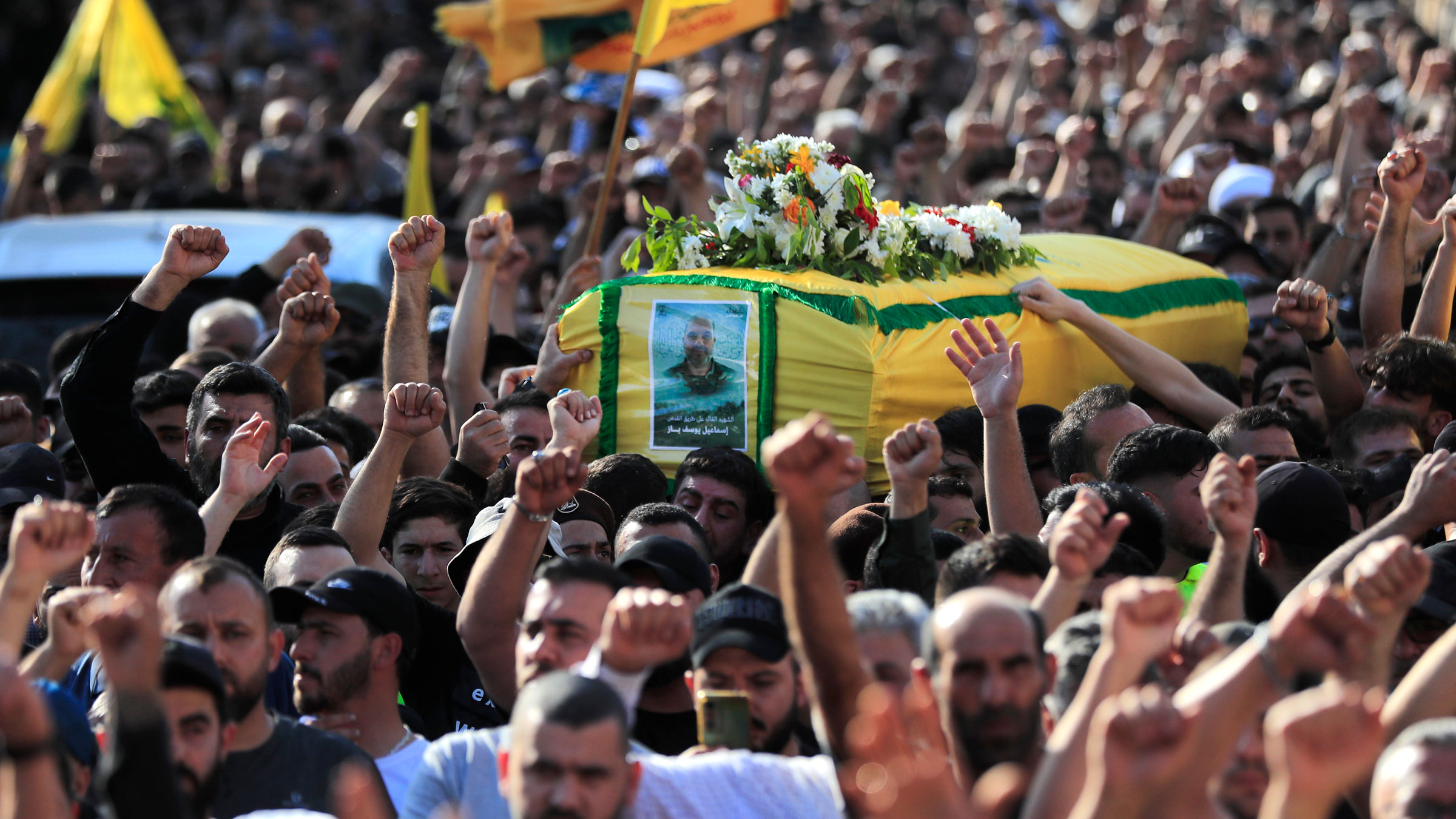 Mourners raise their hands and shout slogans as they carry the coffin of Ismail Baz, a Hezbollah commander who was killed by an Israeli drone strike, during his funeral procession in the Lebanese village of Chehabiyeh on April 17.