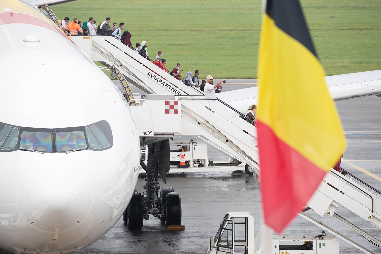 People disembark from a chartered Air Belgium plane carrying evacuees from Afghanistan, at a military airport in Melsbroek, Belgium, on Monday, August 23. 