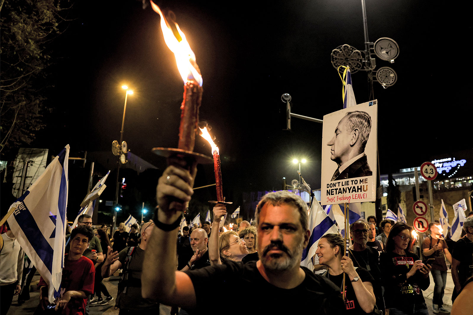 Anti-government protesters gather with signs and candles as they stage a four-day sit-in Jerusalem on Tuesday, April 2, calling for the dissolution of the Israeli government and the return of Israelis held hostage in Gaza by Palestinian militants since the October 7 attacks. 