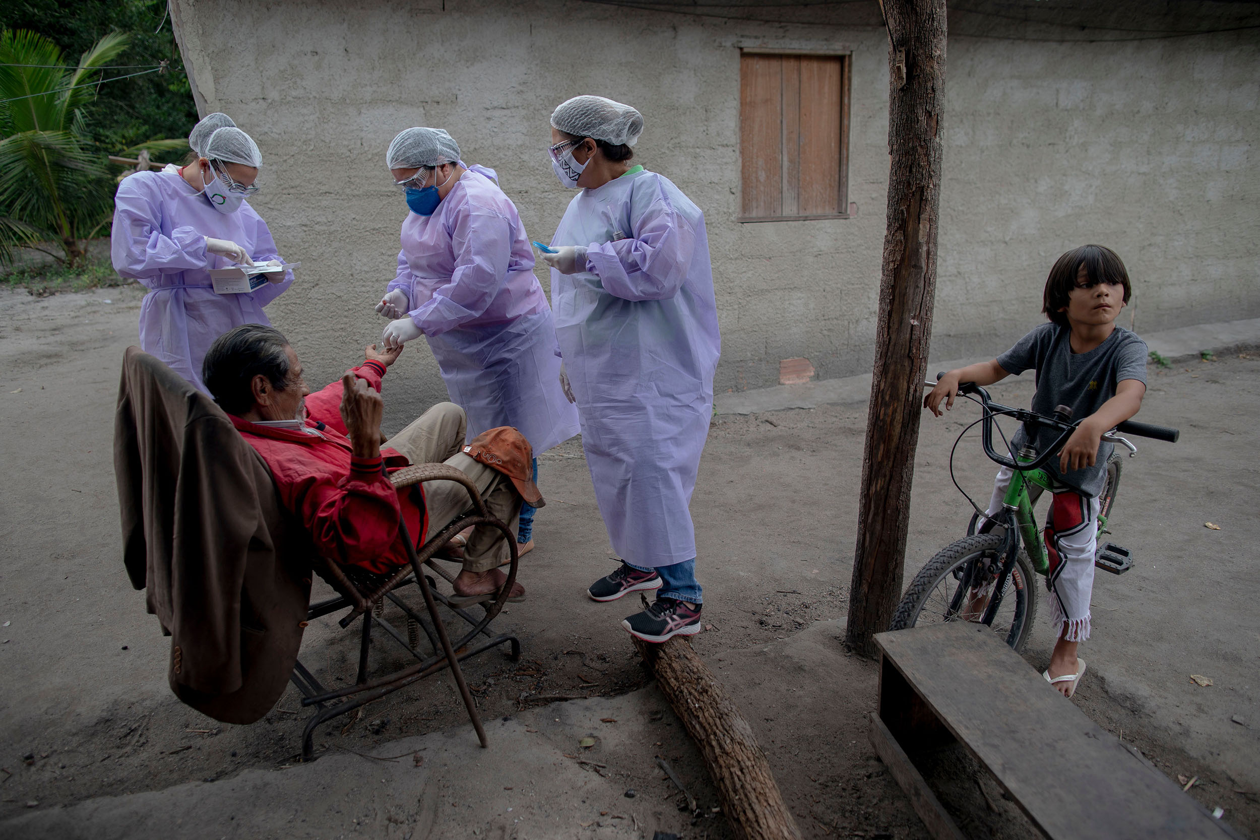 Health professionals administer COVID-19 tests to an elderly indigenous Guarani man in Marica, Brazil, on July 2. 