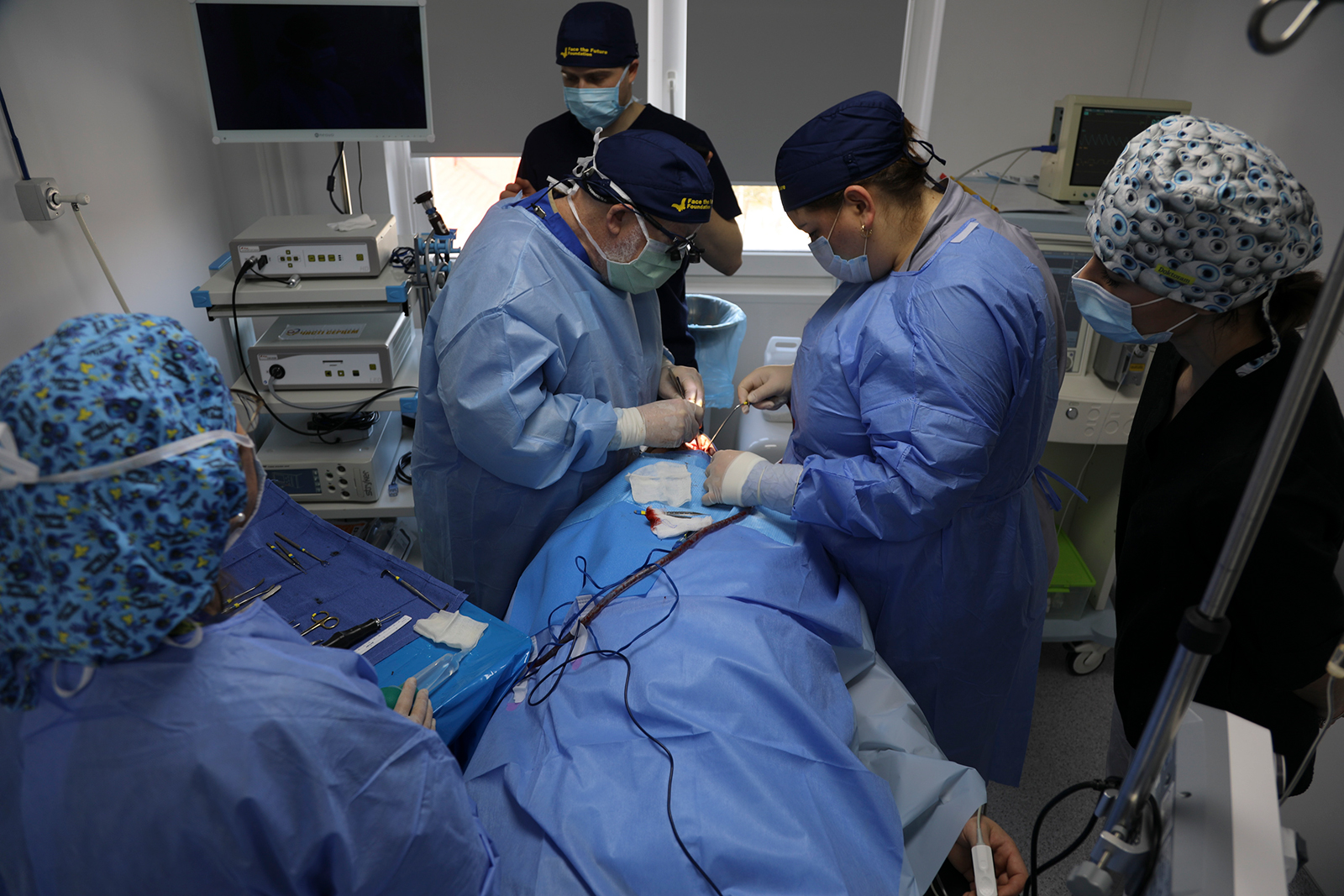 Dr. John Frodel, left, operates on Roman Belinsky, an injured Ukrainian serviceman, in Ivano-Frankivsk regional hospital.