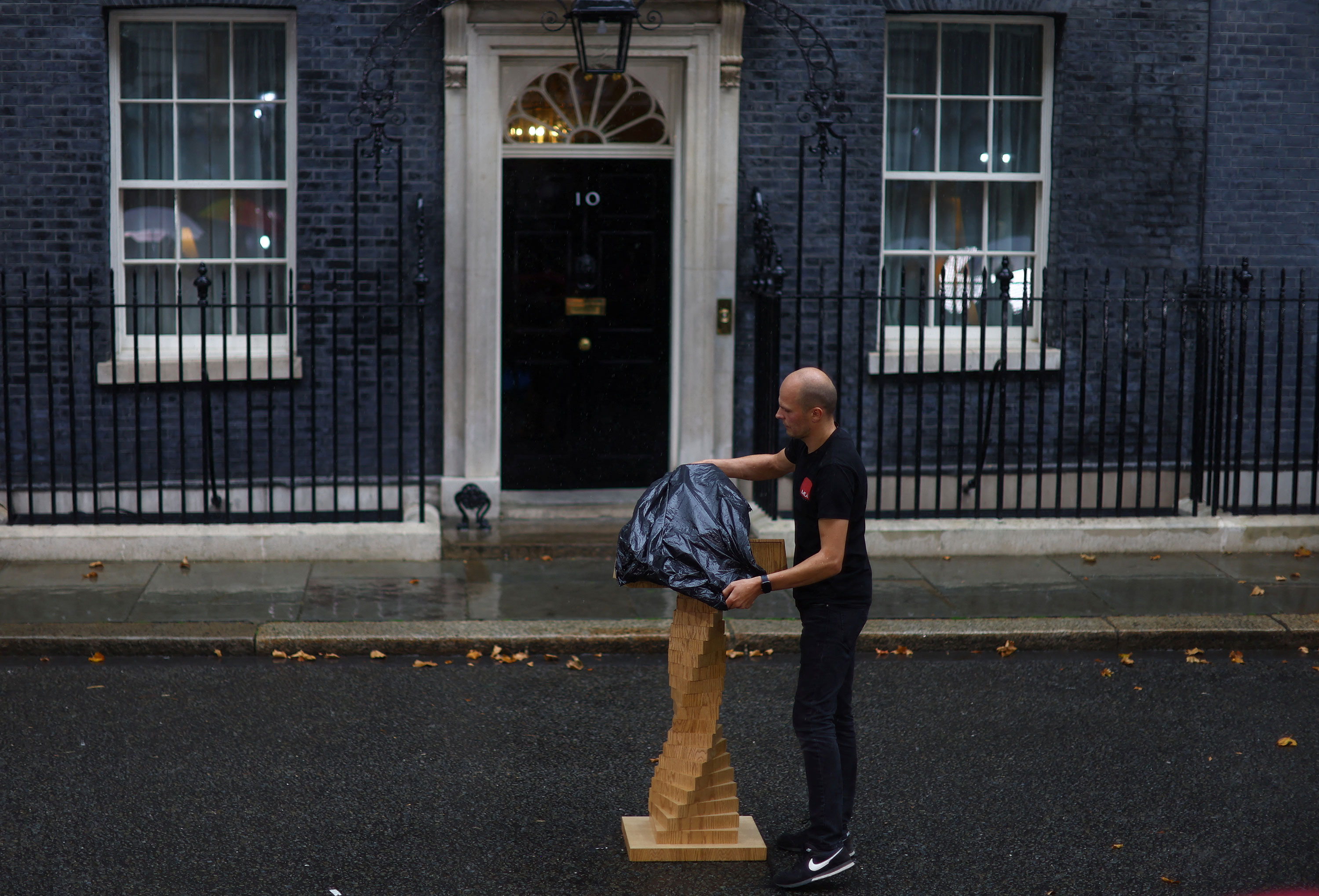 A podium is covered with a plastic bag as it rains ahead of new British Prime Minister Liz Truss's arrival at Downing Street in London on Tuesday.