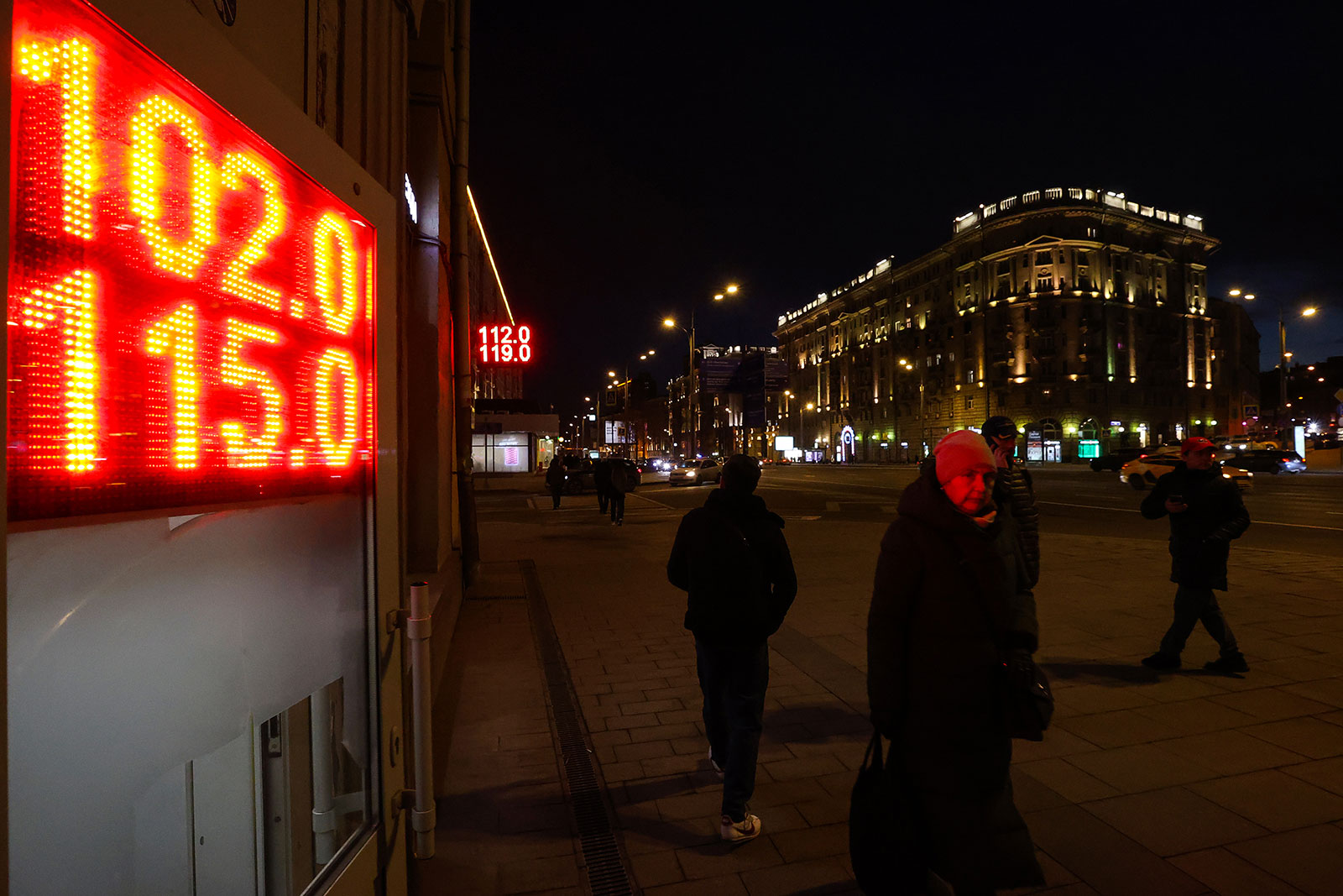 People walk by sign displaying currency exchange rates in Moscow, Russia, on March 2.
