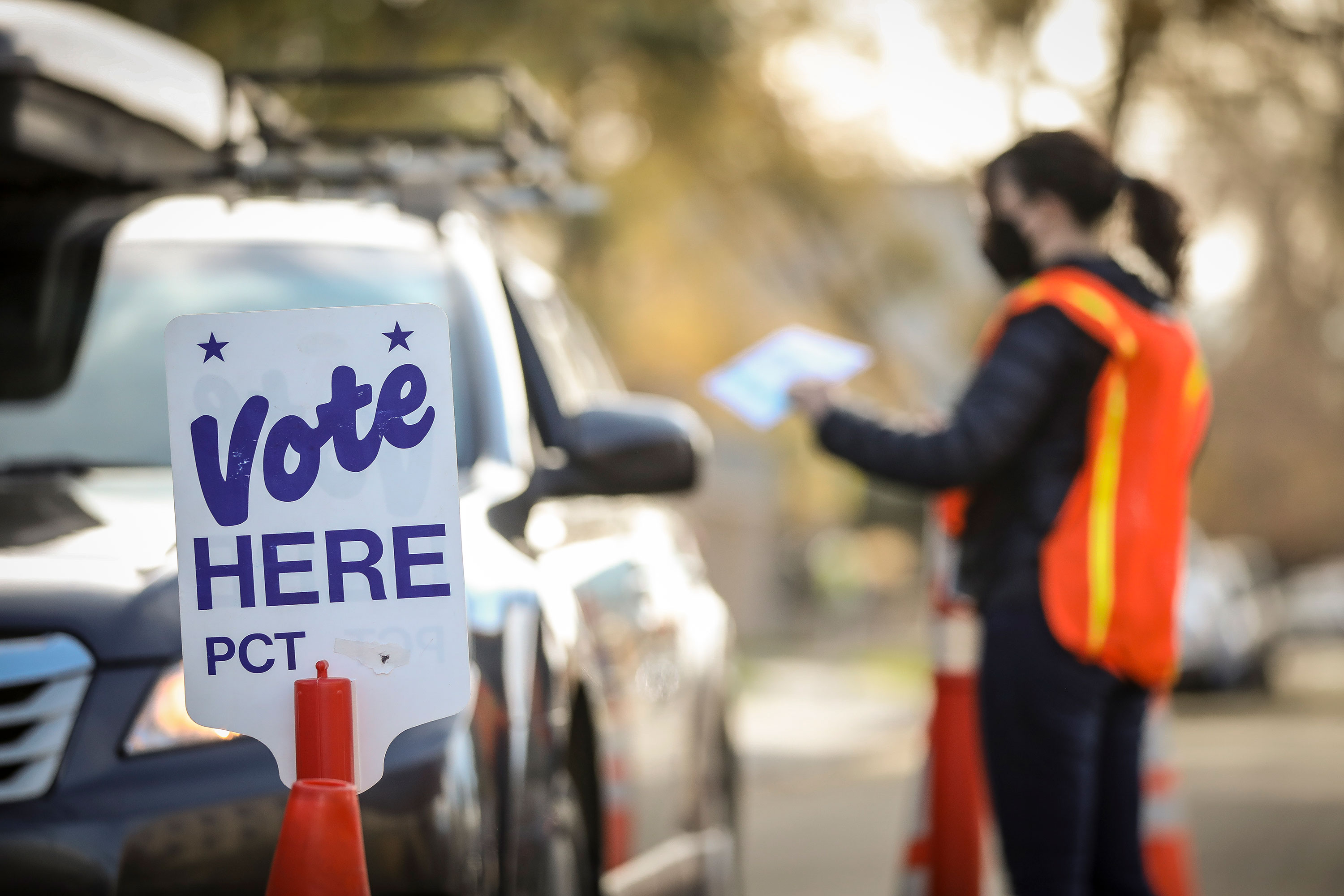 An election judge accepts a ballot at a drive-thru ballot drop location in Denver, Colorado on November 3. 