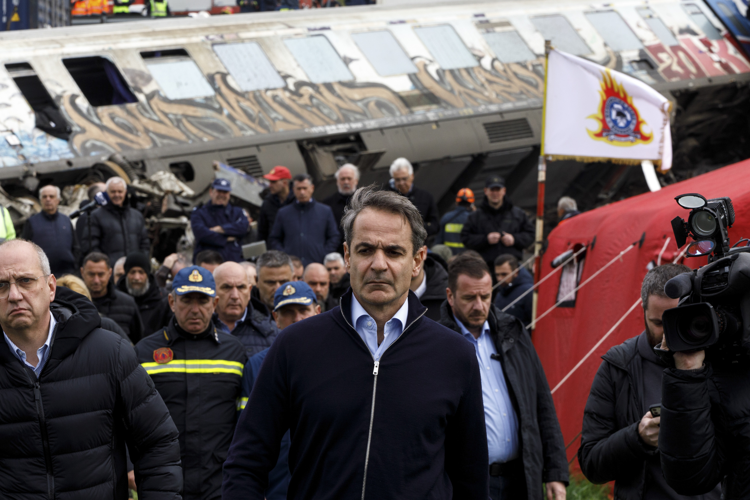 Greece's prime minister Kyriakos Mitsotakis, center, visits the site of the crash. 
