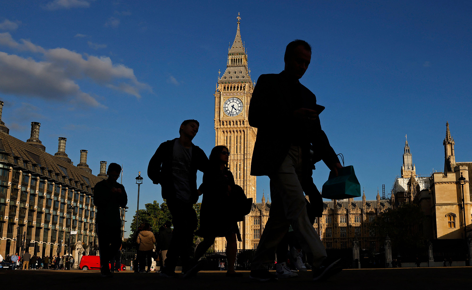 Pedestrians walk past the Elizabeth Tower at the Houses of Parliament in central London, UK, on October 11, 2022. 