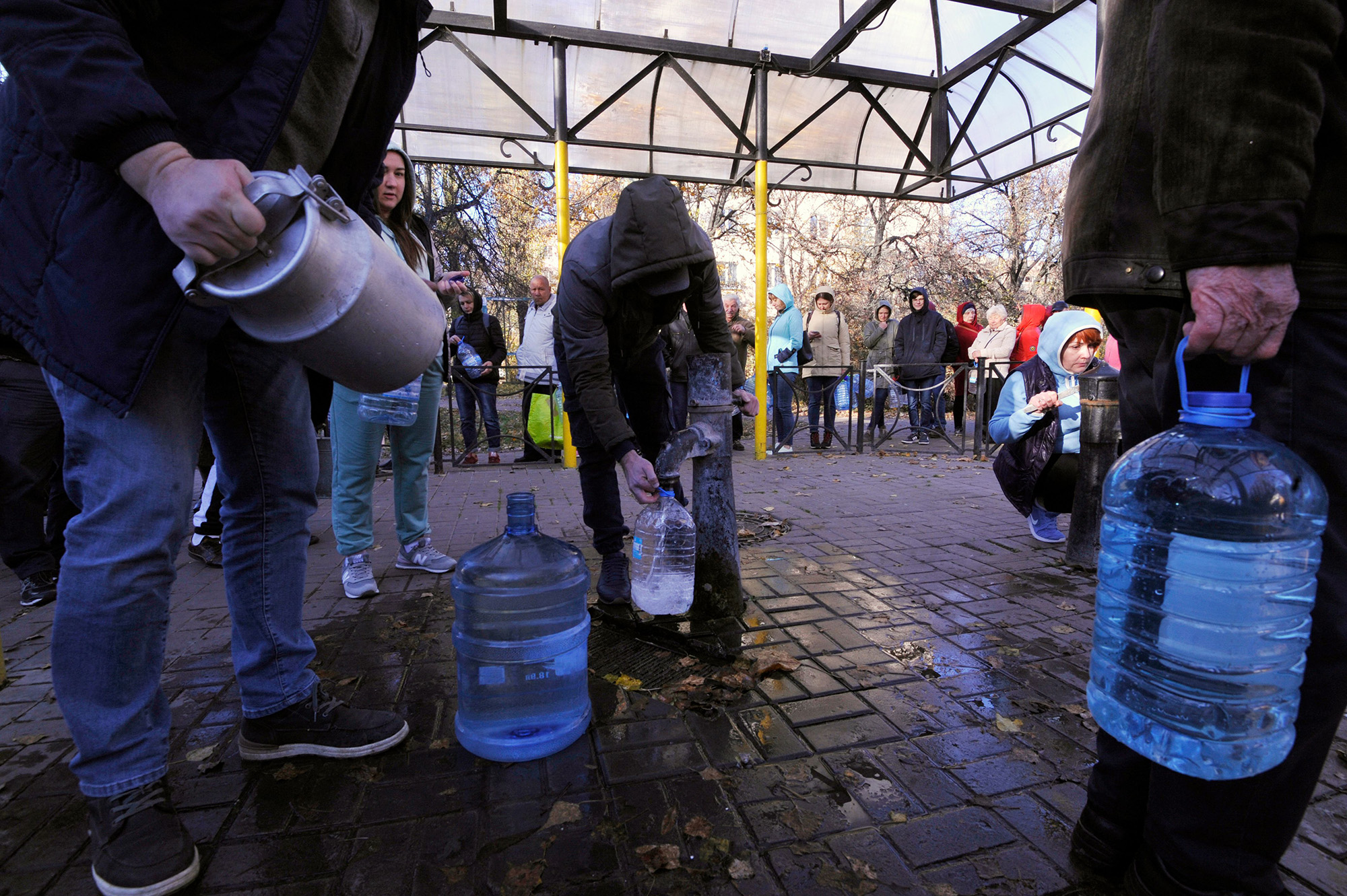 Local residents wait in line to collect water from a public water pump in a park in Kyiv, Ukraine, on October 31.