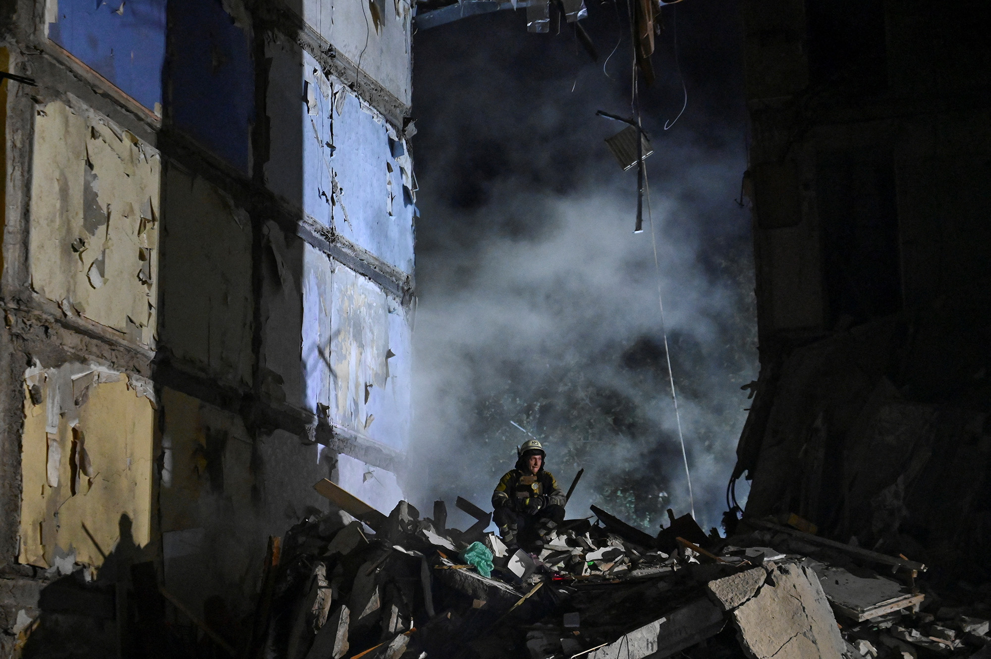 A rescue worker stands in the debris of a residential building heavily damaged by a Russian missile strike in Zaporizhzhia, Ukraine on October 9.