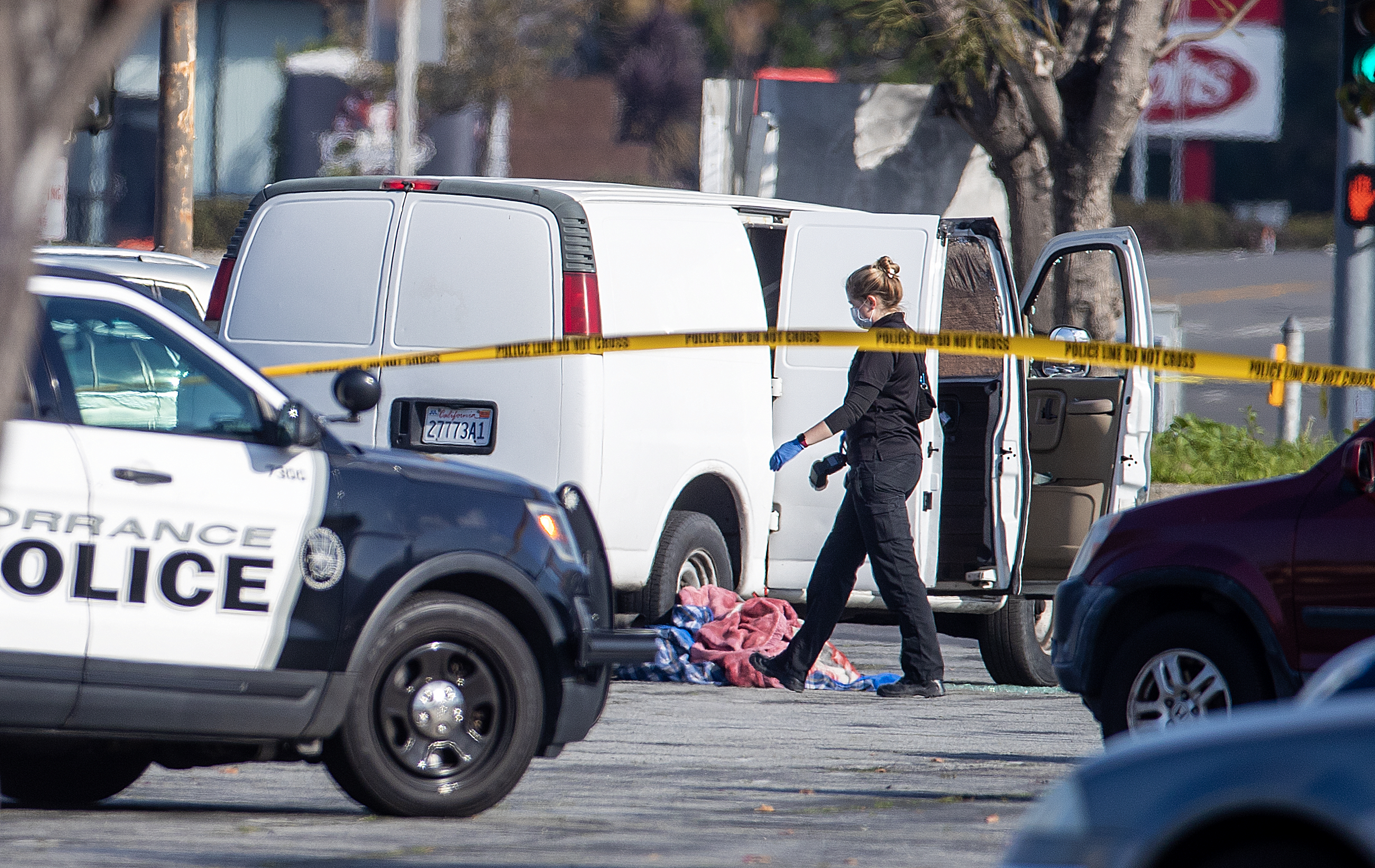A coroner official investigates the scene of a van believed to be tied to the Monterey Park ballroom shooting on Sunday.