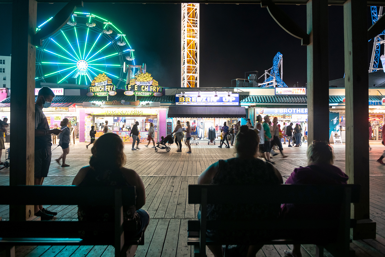 People sit on benches facing the ferris wheel in Ocean City, New Jersey on September 7.