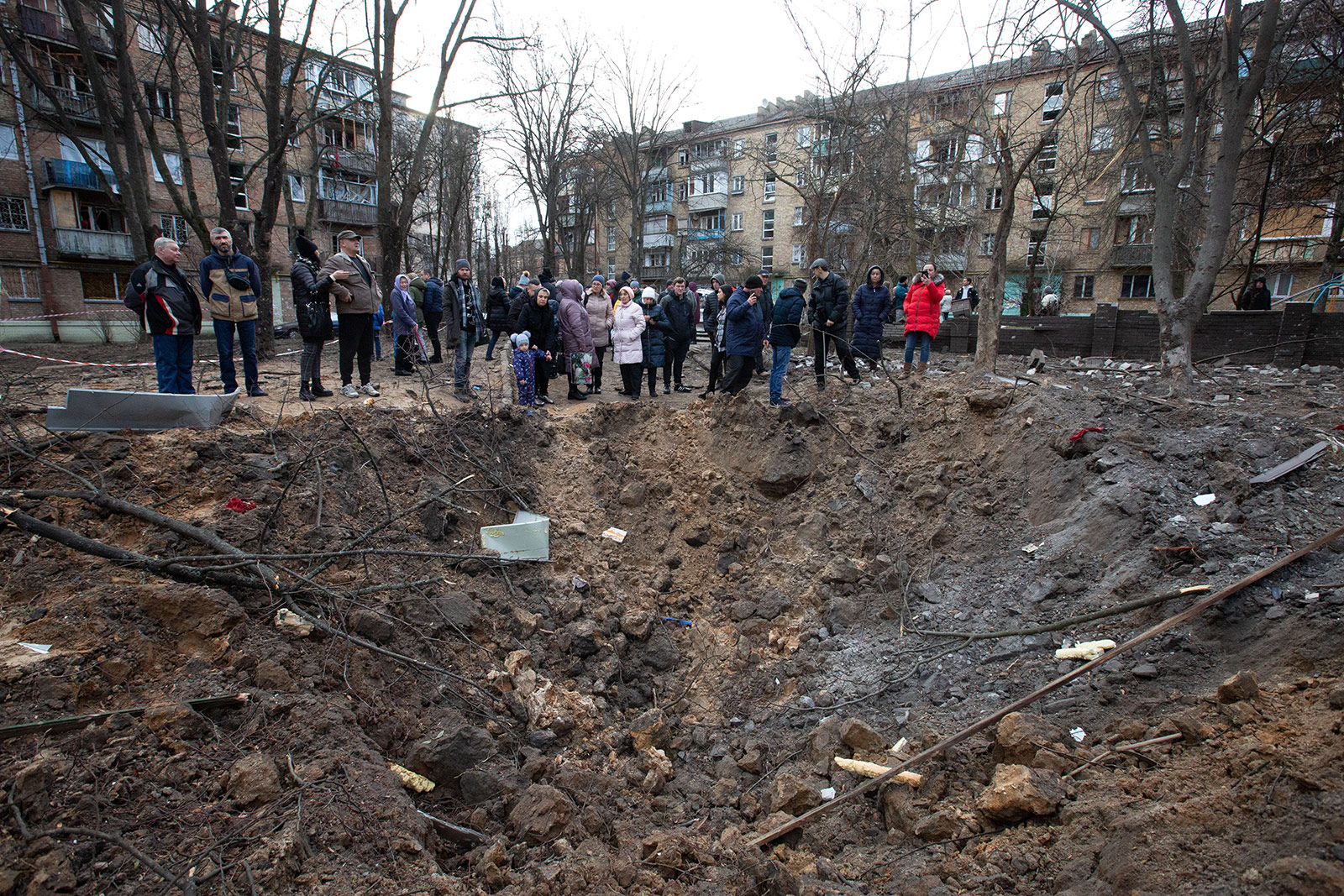 Residents stand near a crater created by a missile attack in Kyiv, Ukraine, on January 1. 