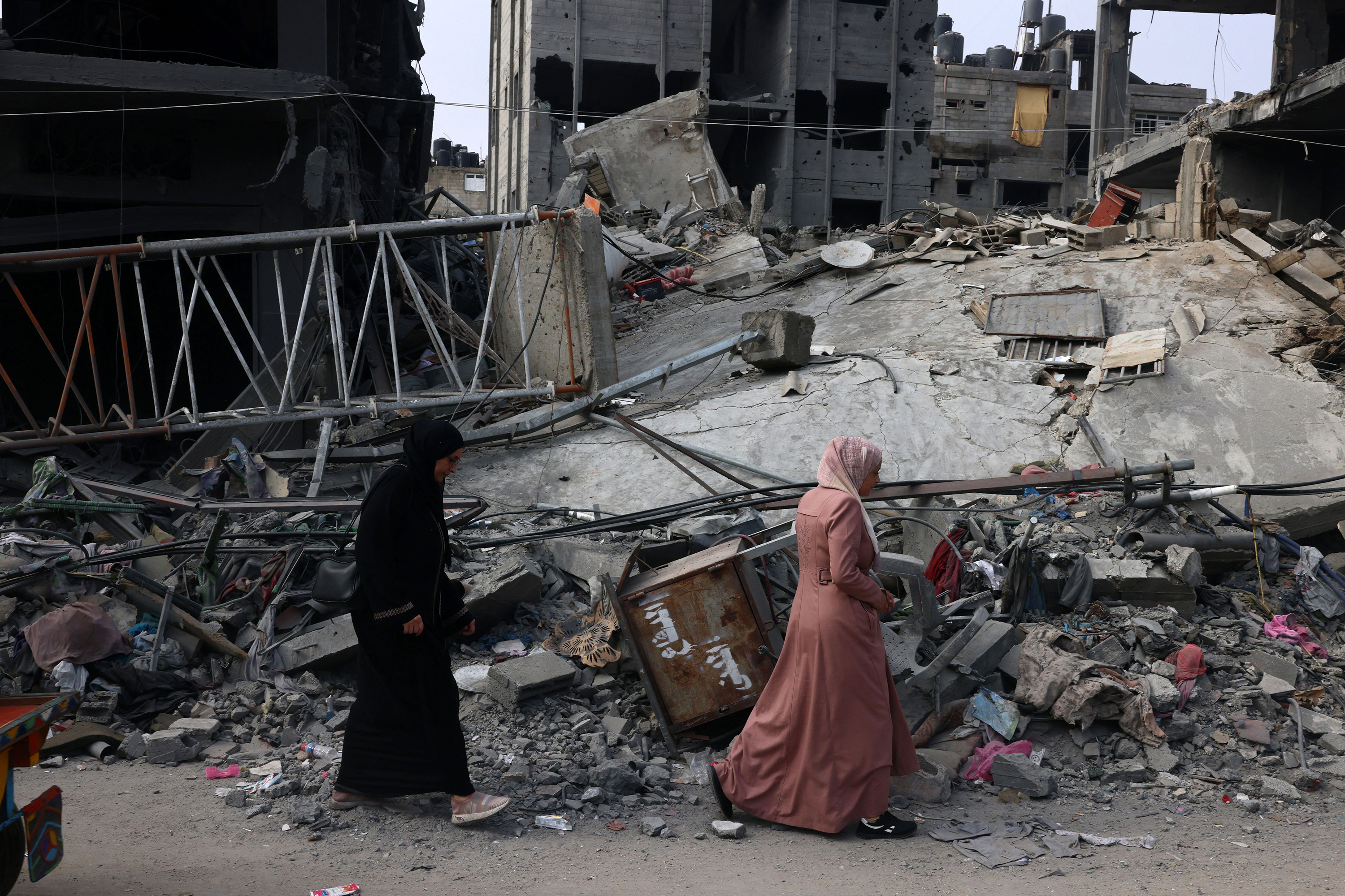 Women walk past a destroyed building in the aftermath of Israeli bombing in Rafah, Gaza on October 28.