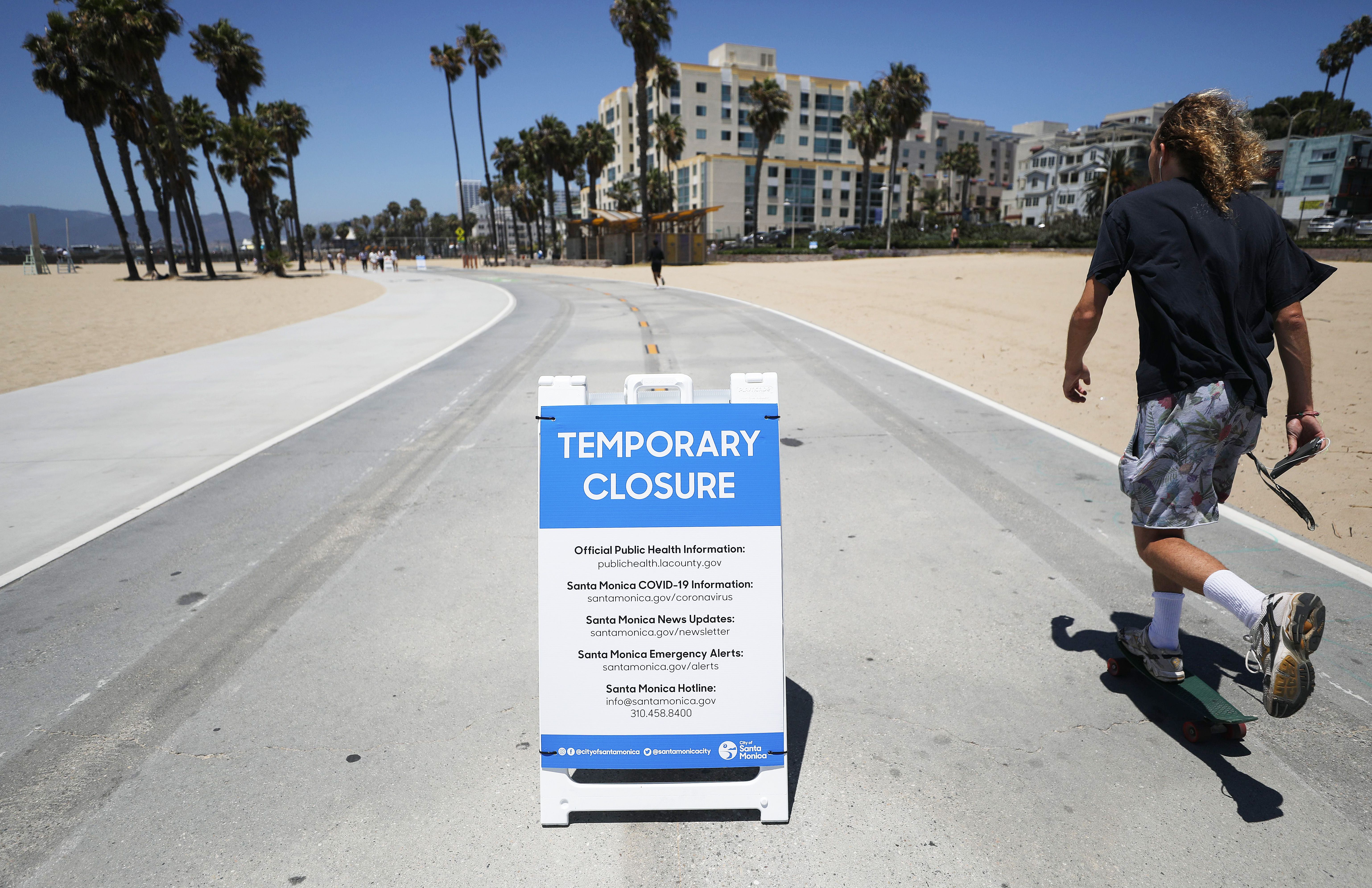 A man skates along the closed and nearly empty Santa Monica beach on July 3 in Santa Monica, California. 