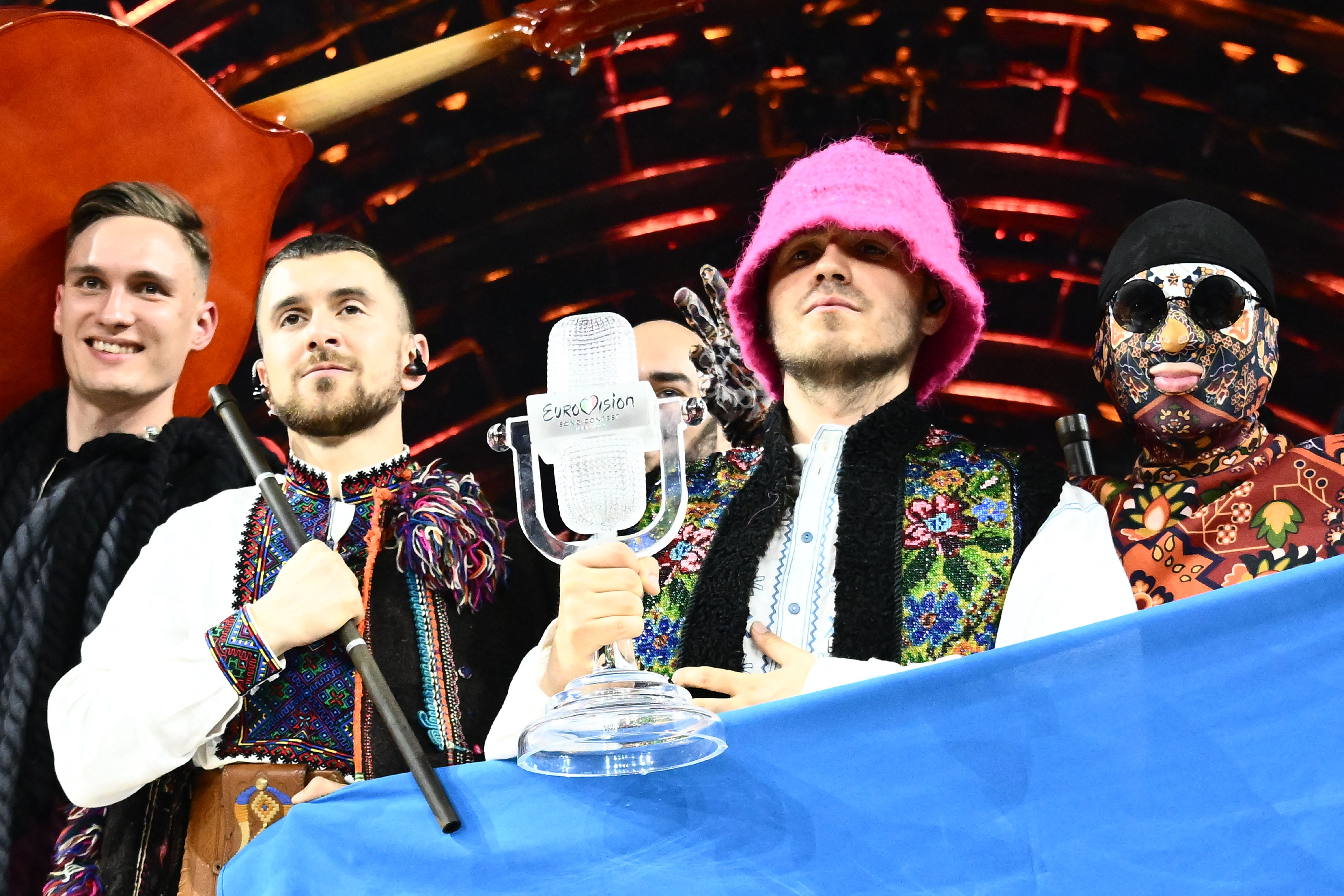 Kalush Orchestra pose onstage with the winner's trophy and Ukraine's flags after winning the Eurovision Song contest 2022 on May 14, in Turin. 