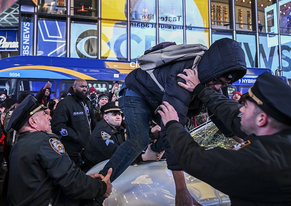 Police officers take a demonstrator, who smashed the window of a police car, into custody during the protest against the police assault of Tyre Nichols at Times Square in New York, on Friday, January 27. 