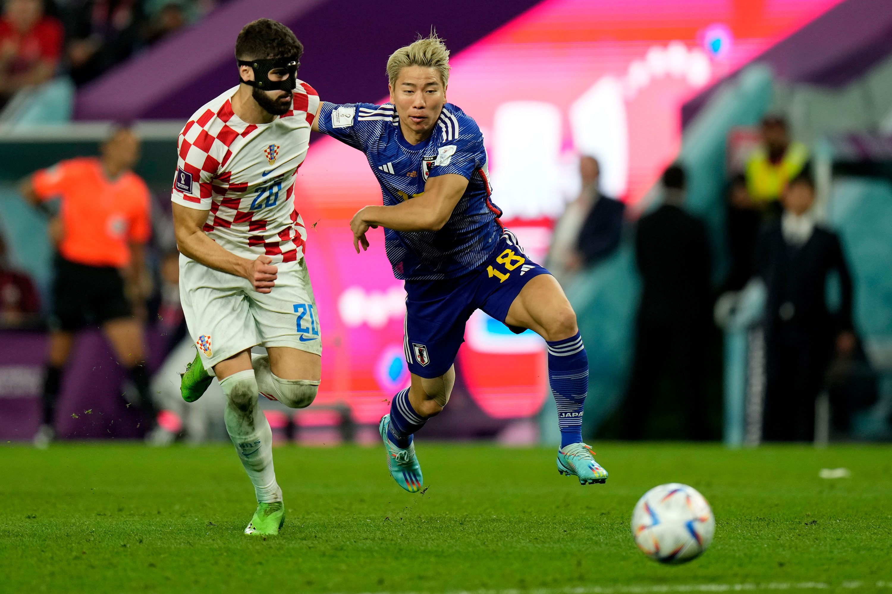 Croatia's Joško Gvardiol, left, and Japan's Takuma Asano run toward the ball.