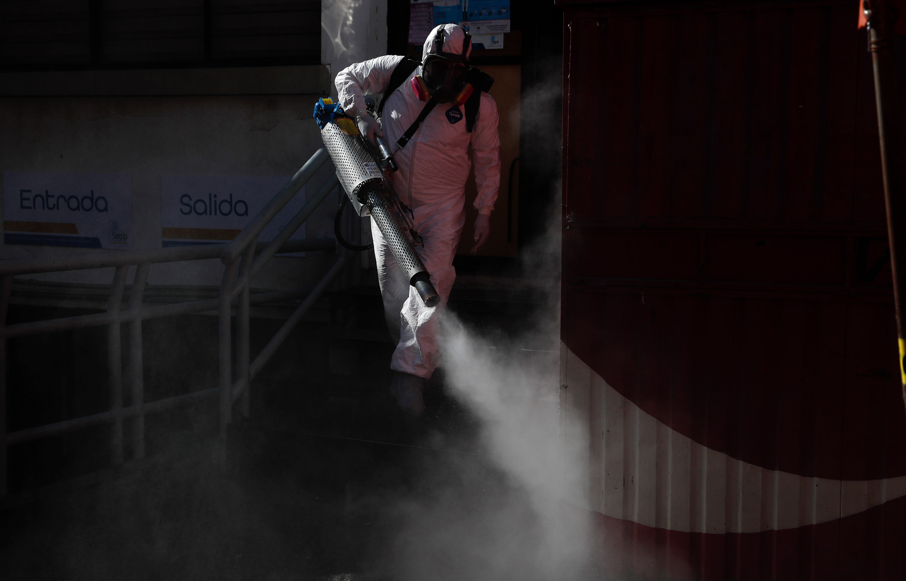 A city worker disinfects the entrance to the government identification office in La Paz, Bolivia, on June 16.