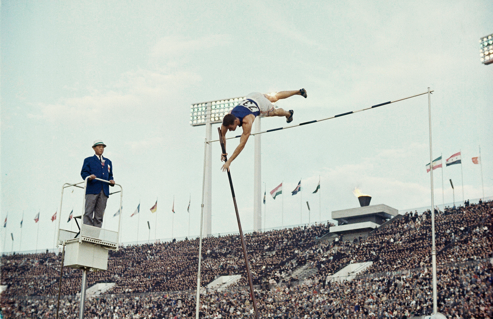 A pole vaulter clears the bar during competition.