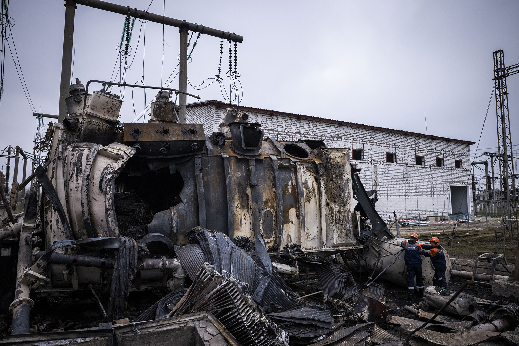 Workers dismantle an autotransformer which stands completely destroyed after the Ukrenergo high voltage power substation was hit by a missile strike on October 17, in central Ukraine.