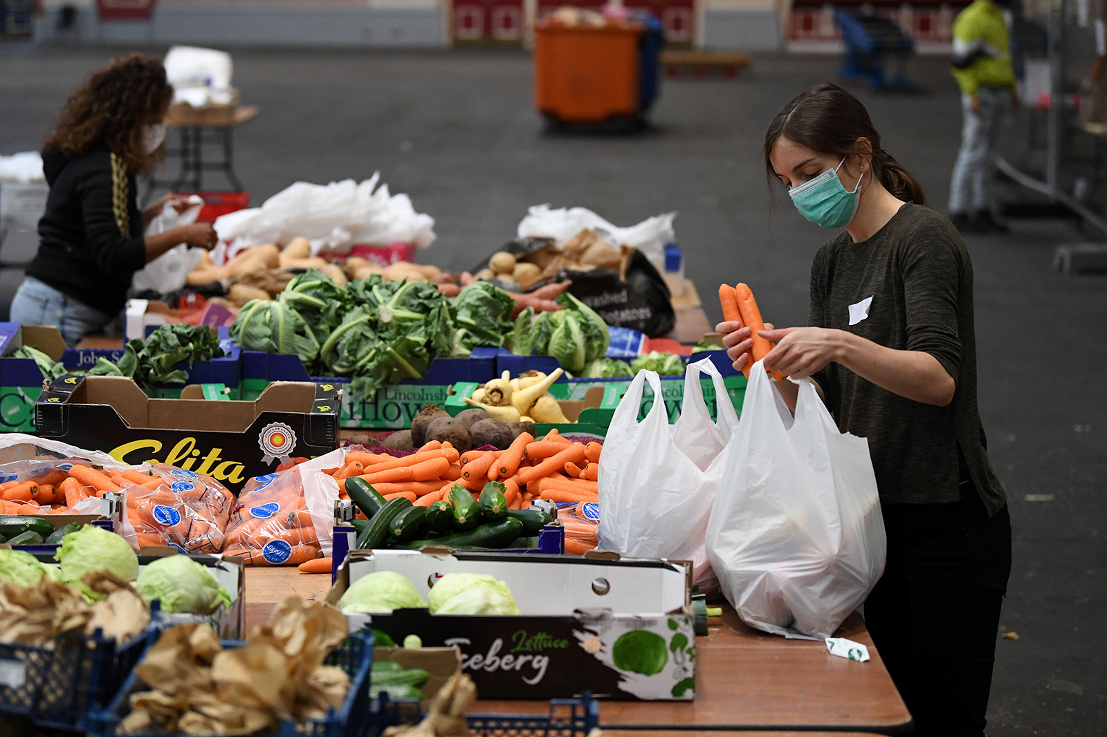 Volunteers sort food and create food parcels for those in need at a temporary food bank center in London on April 29.