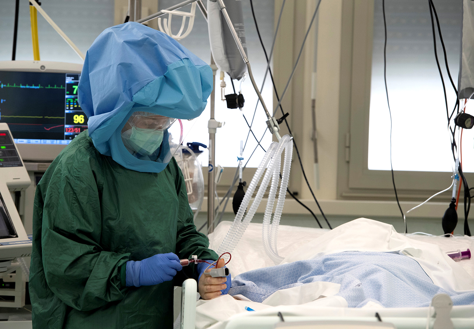 A health worker wearing protective gear takes care of a patient at the intensive care unit, treating COVID-19 patients, of the Tor Vergata Hospital in Rome, on May 12.