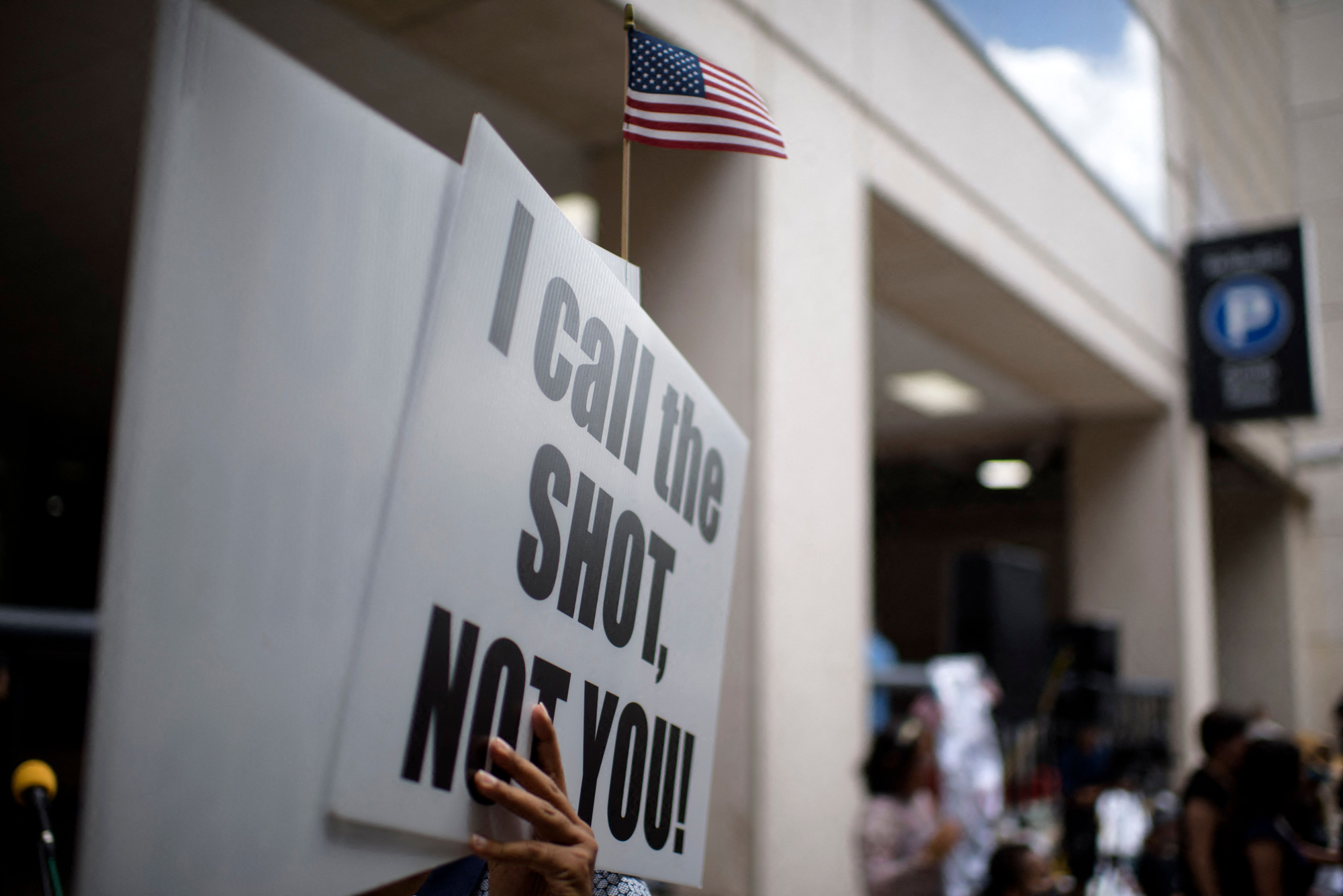 Anti-vaccine rally protesters hold signs outside of Houston Methodist Hospital in Houston, Texas, on June 26.