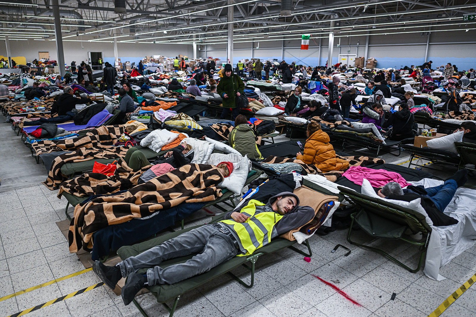 People who fled the war in Ukraine rest inside a temporary refugee shelter after being transported from the Polish Ukrainian border on March 8 in Przemysl, Poland. 