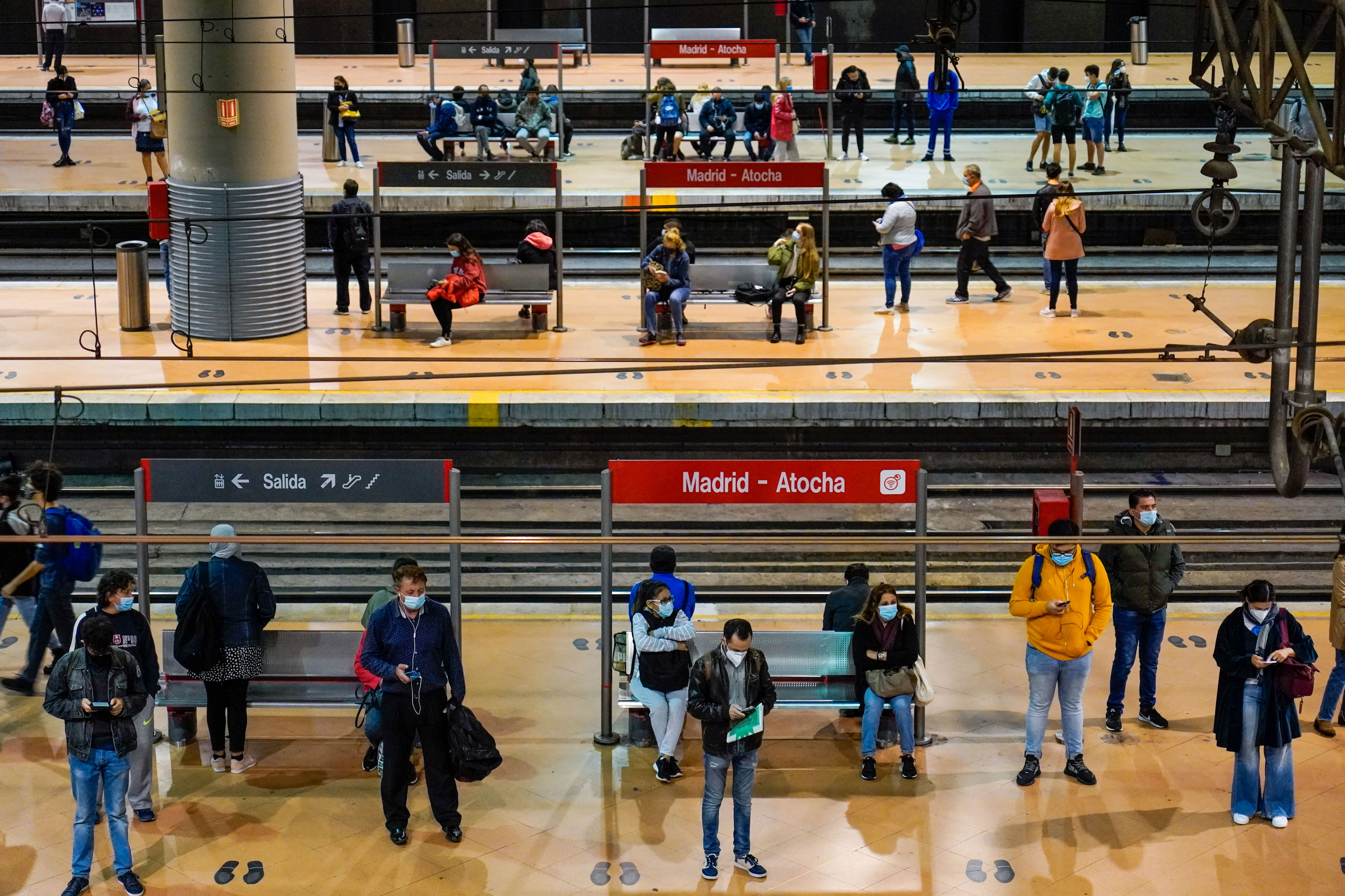 People wait for trains at Atocha railway station in Madrid on October 2.