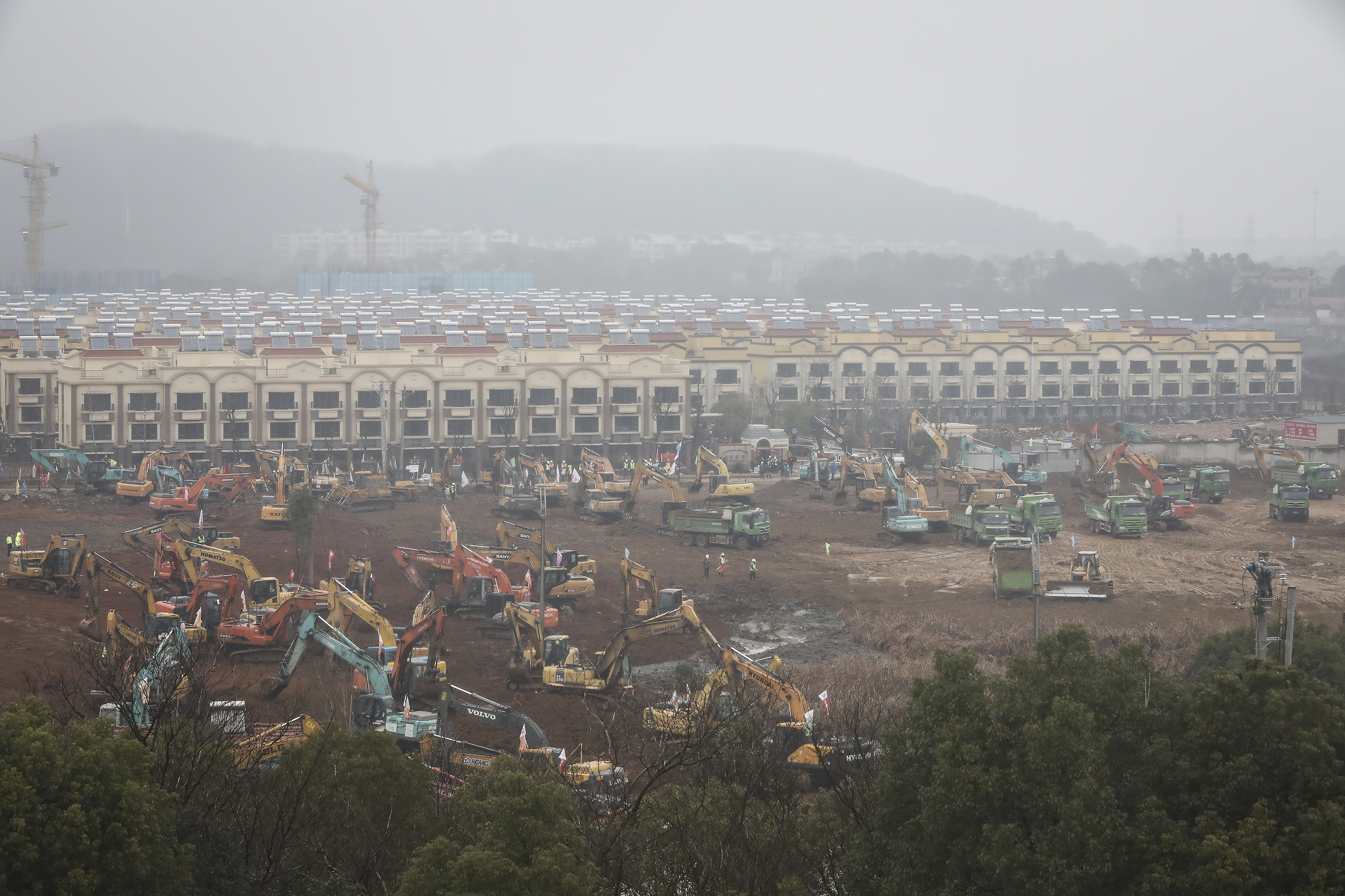 Construction workers drive excavators at the site of a new 1,000-bed hospital being built to accommodate the increasing number of coronavirus patients in this photograph taken on January 24, 2020.
