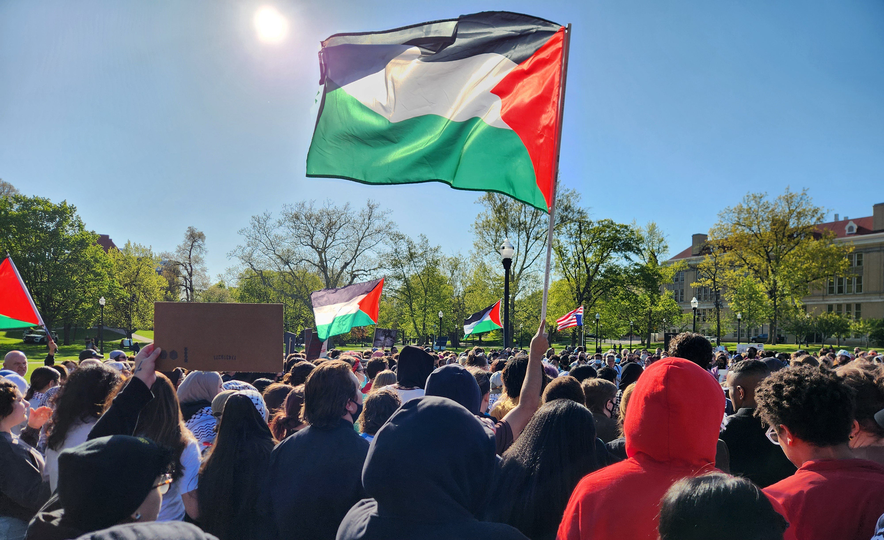 Protestors wave Palestinian flags and call for Ohio State University to divest investment in businesses linked to Israel at a demonstration outside the Ohio Union on April 25.